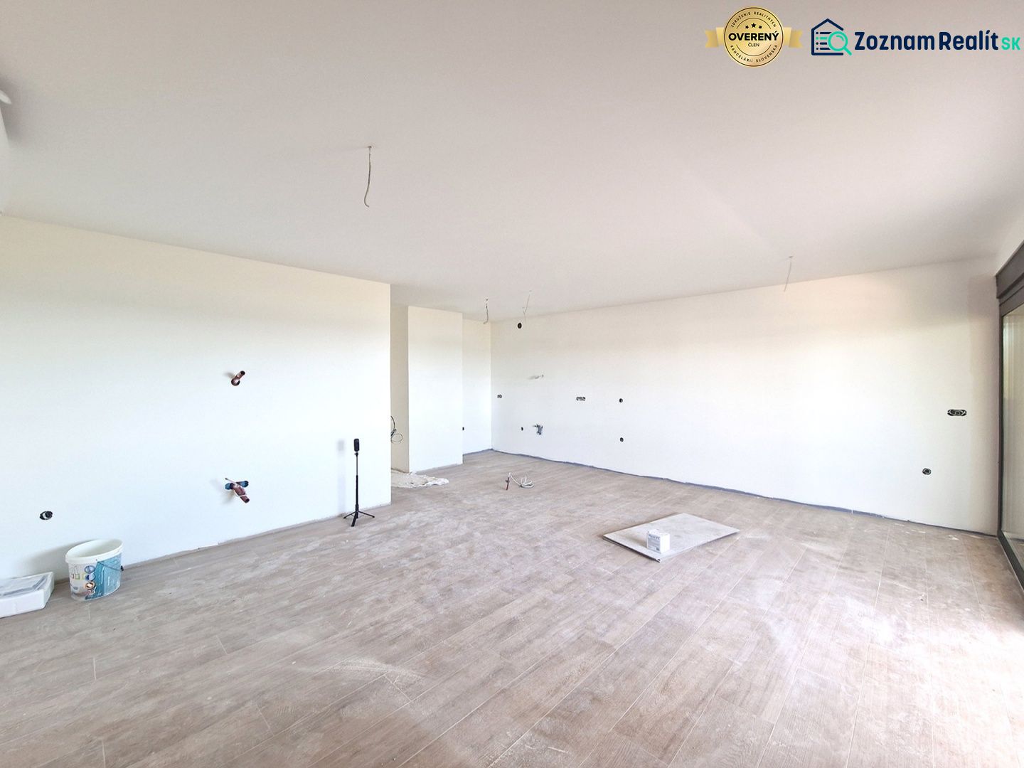 Geräumiges Zimmer einer 3-Zimmer-Wohnung mit Holzboden und großem Fenster.