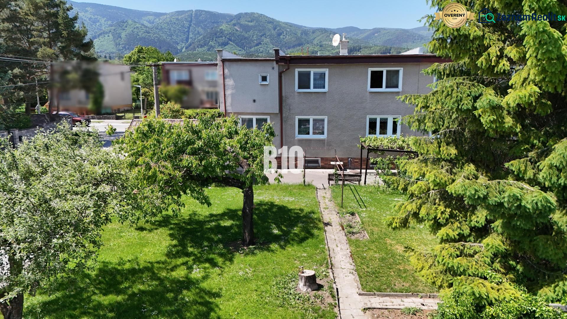 Ein Einfamilienhaus in Martin mit einem weitläufigen Garten und Bergen im Hintergrund.