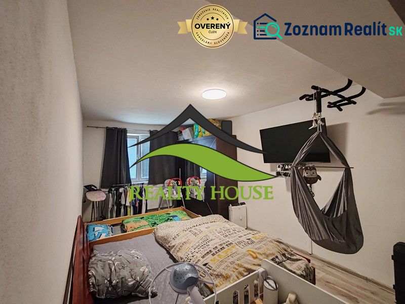 Ein Kinderzimmer in einer 3-Zimmer-Wohnung mit einem Bett und einem Fernseher an der Wand.