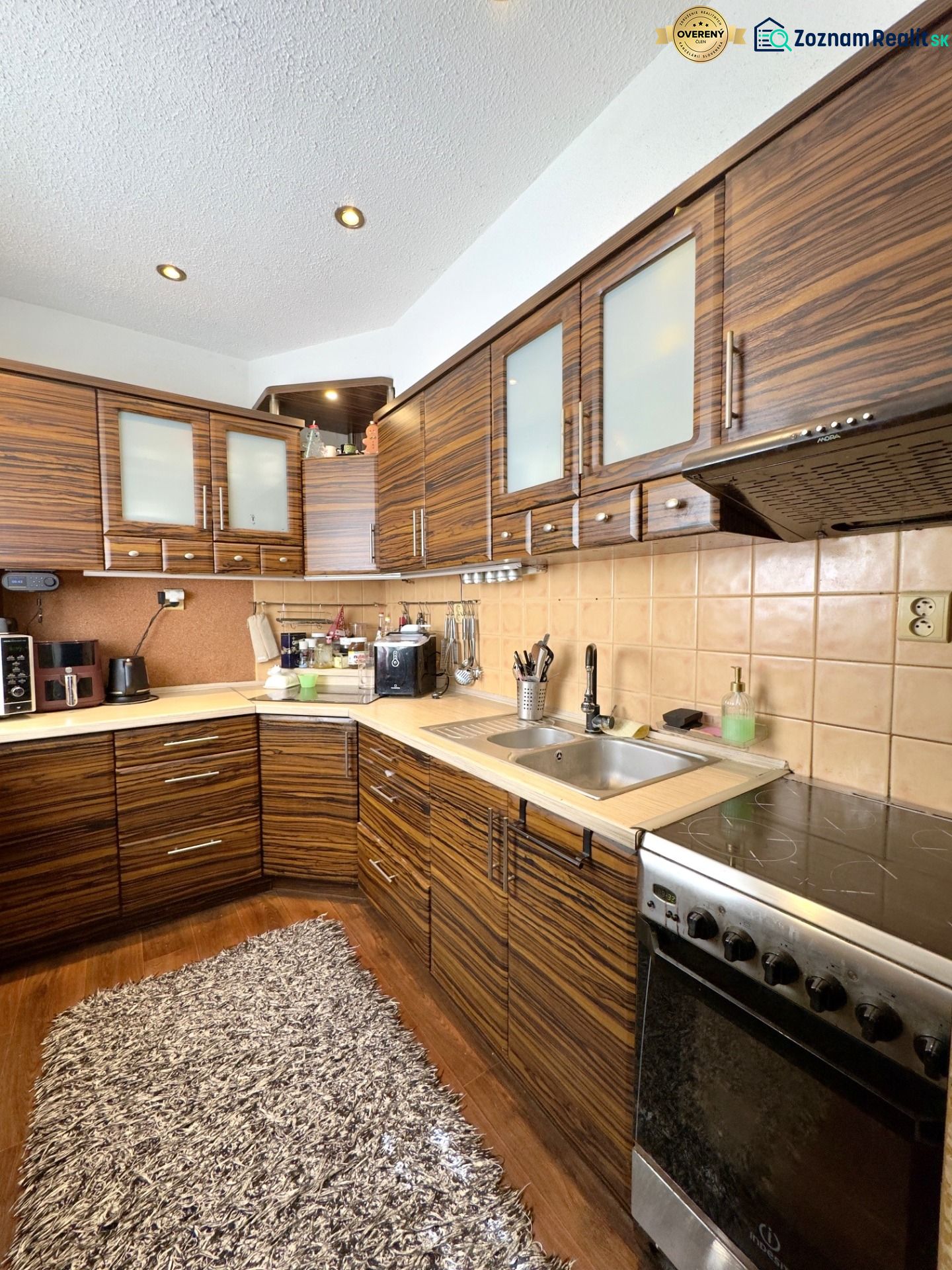 Küche in einer 4-Zimmer-Wohnung mit Holzboden und Geräten.