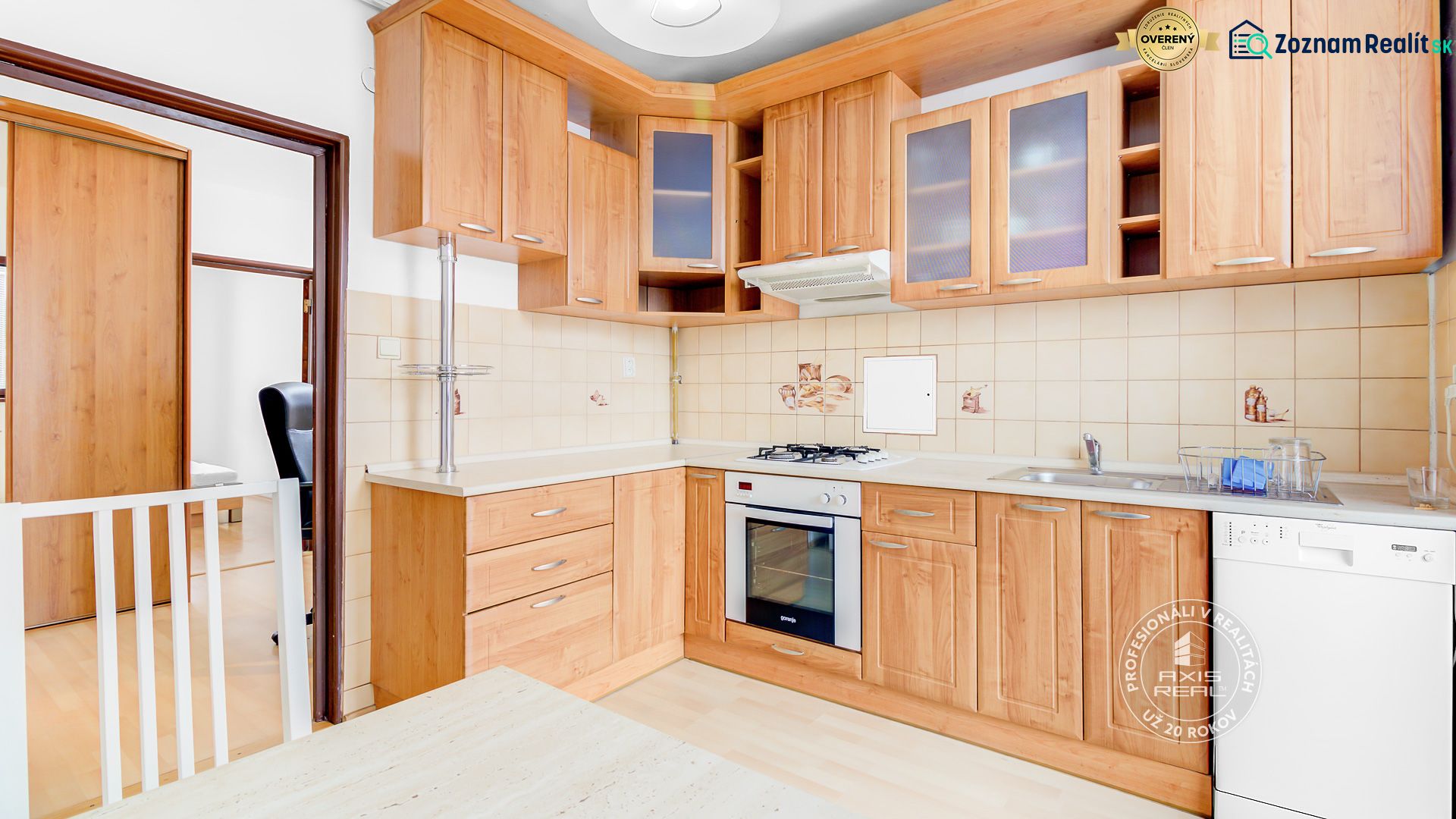 Küche in einer 2-Zimmer-Wohnung mit Holzboden und Holzschränken.