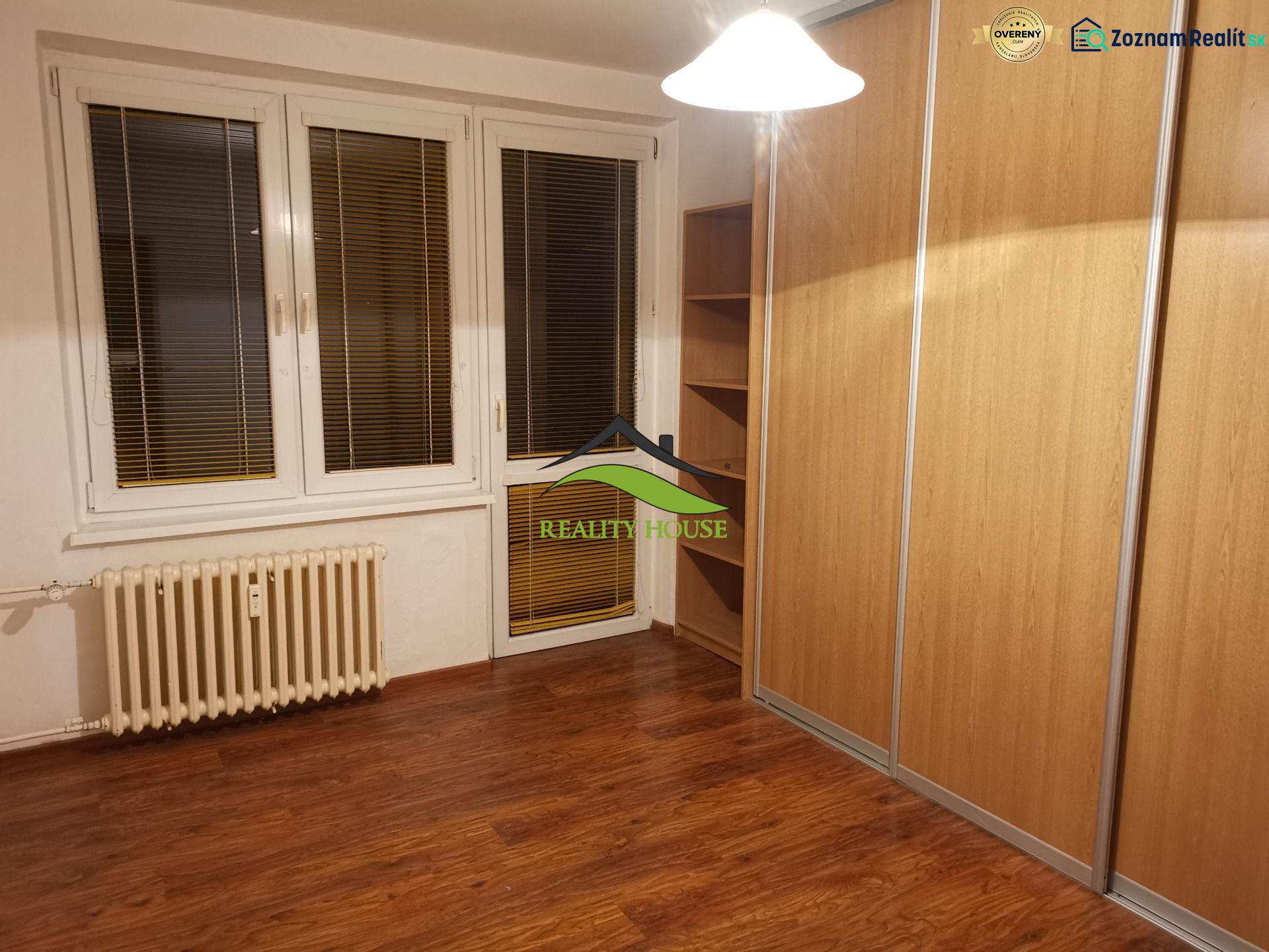 Ein Zimmer mit einem Holzboden und einem großen Einbauschrank in einer 3-Zimmer-Wohnung.