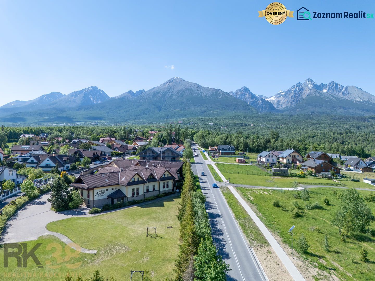 Ein Blick auf Hotels und Pensionen in Nová Lesná mit der Hohen Tatra im Hintergrund.