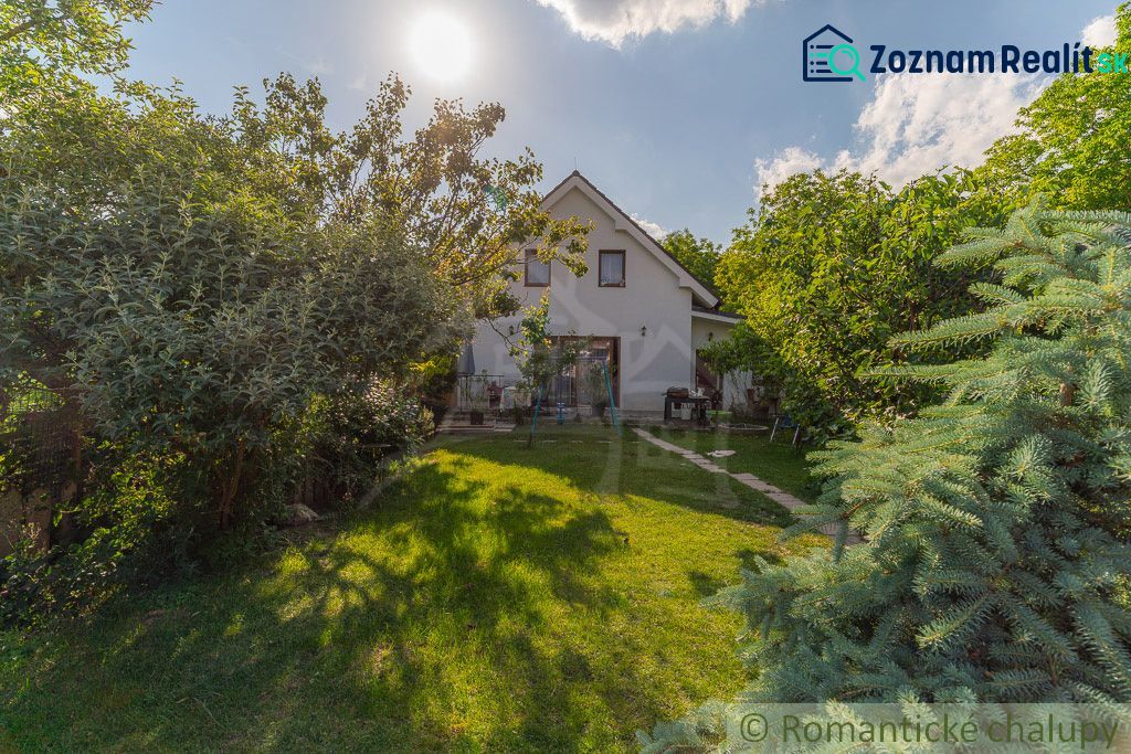 Ein Einfamilienhaus in Bernolákovo, umgeben von einem üppigen Garten auf einem sonnigen Grundstück.