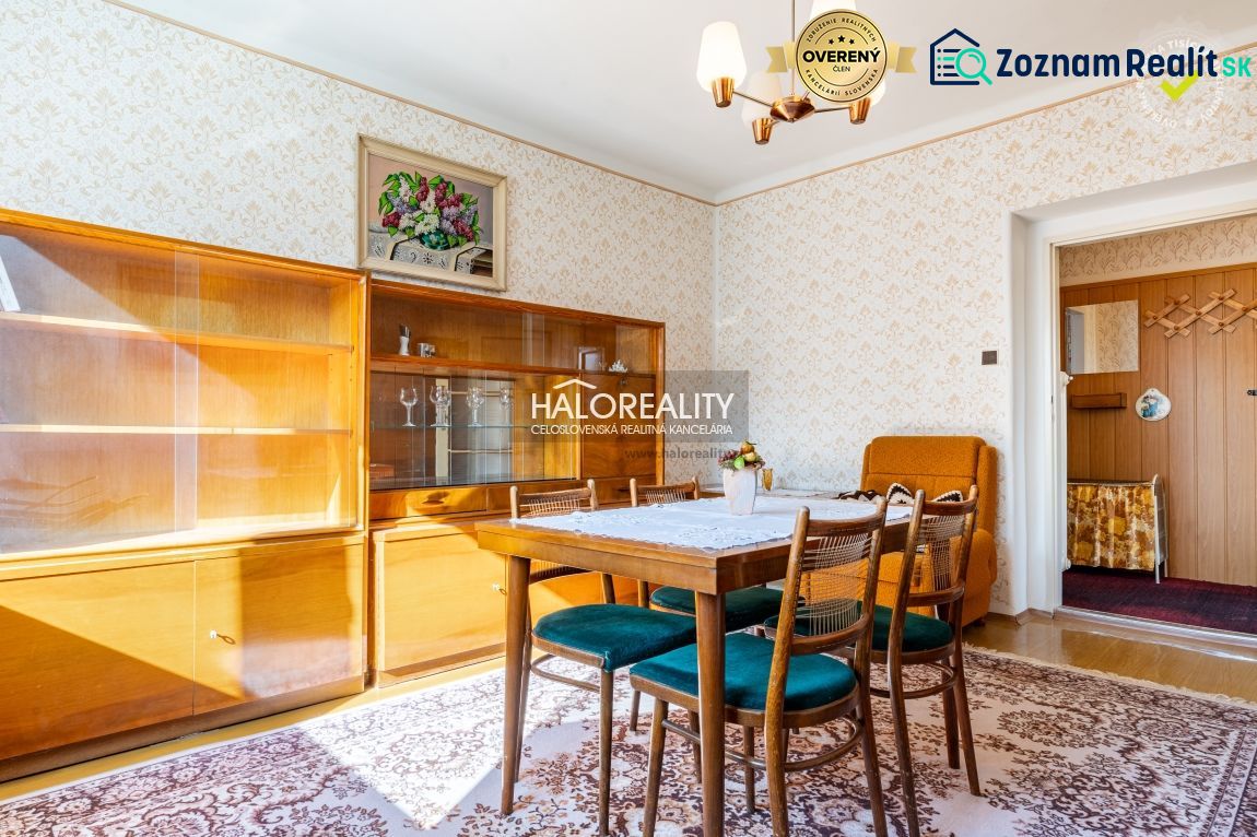 Esszimmer in einem Einfamilienhaus mit Holzmöbeln, Tapeten und Licht von einem Kronleuchter.