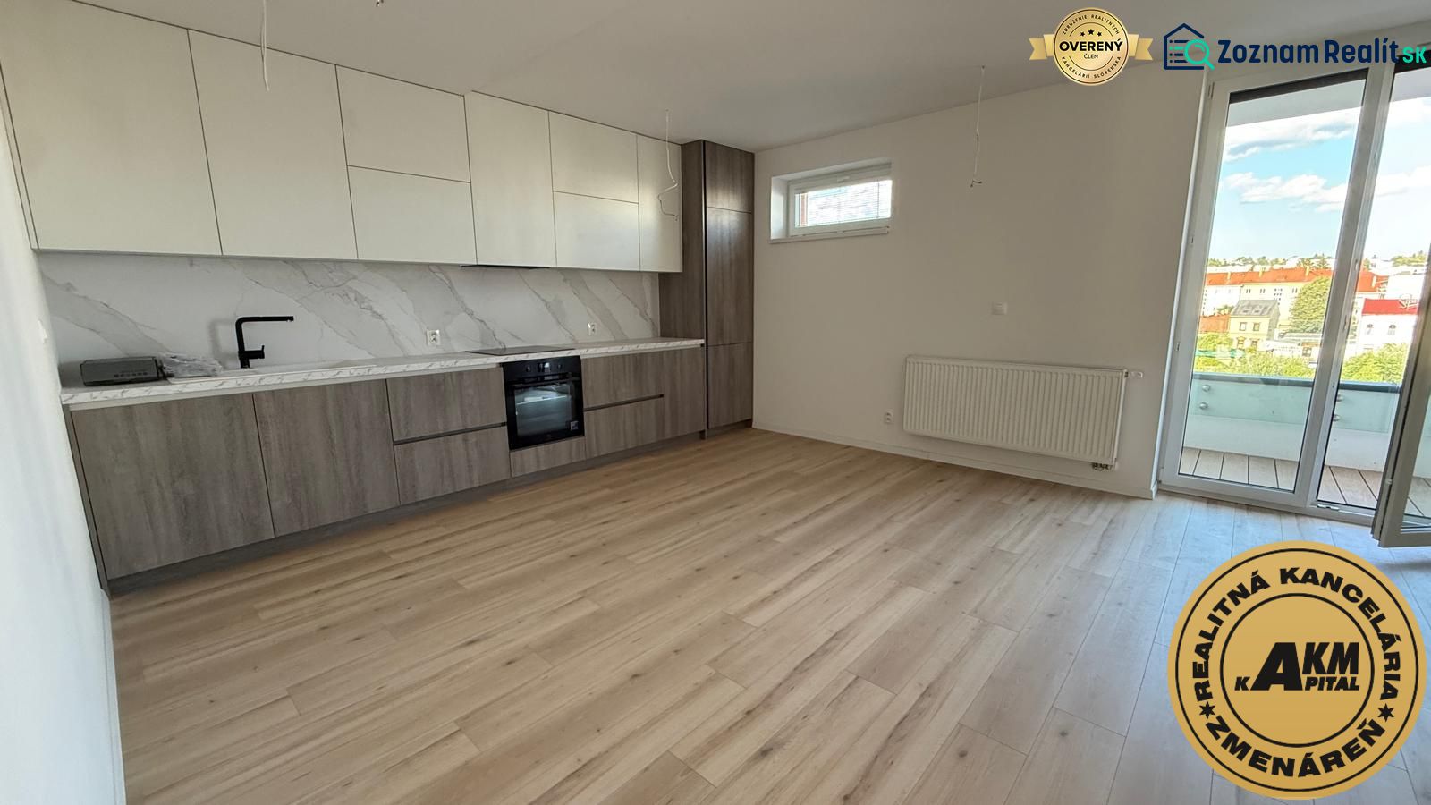 Küche in einer 3-Zimmer-Wohnung mit Holzboden und Balkon.