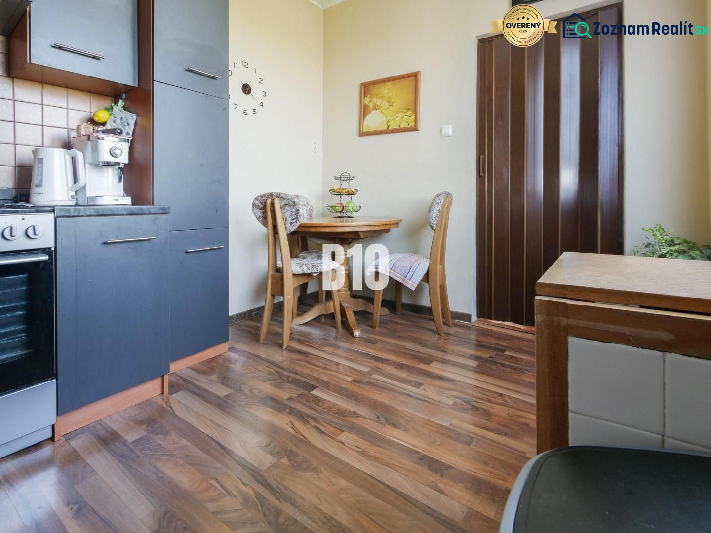 Küchenecke in einer 2-Zimmer-Wohnung mit Holzboden und Esstisch.