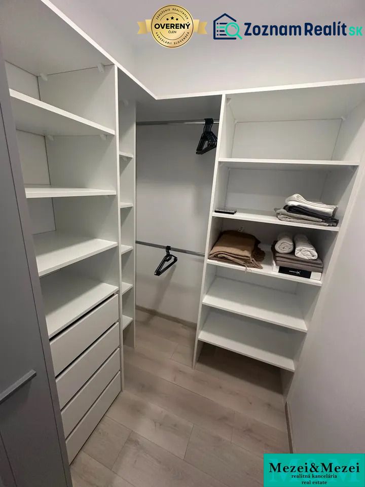 Stauraum mit Regalen, Schubladen und einem Boden mit Holzdekor in einer 2-Zimmer-Wohnung.
