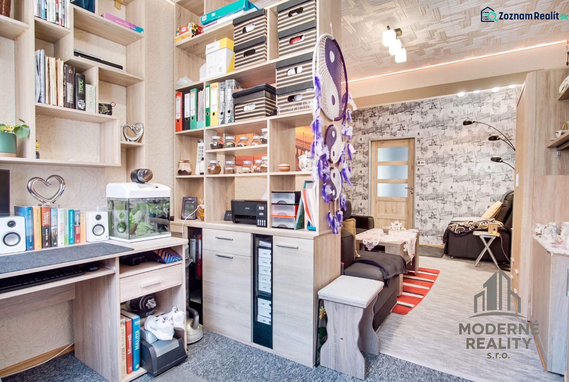 Arbeitsbereich und Wohnzimmer in einer 2-Zimmer-Wohnung mit Regalen und Dekorationen.
