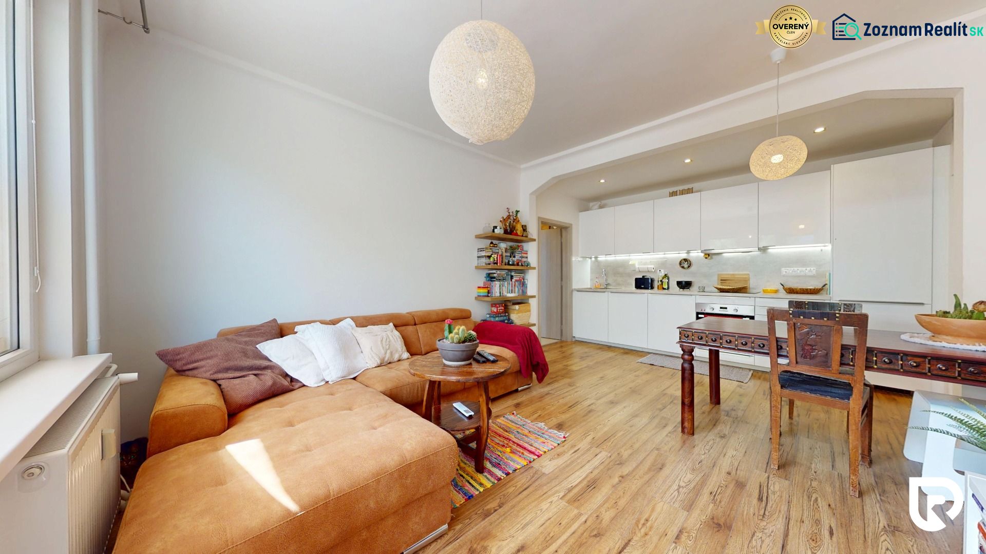 Wohnzimmer mit Küche in einer 3-Zimmer-Wohnung mit Holzboden.