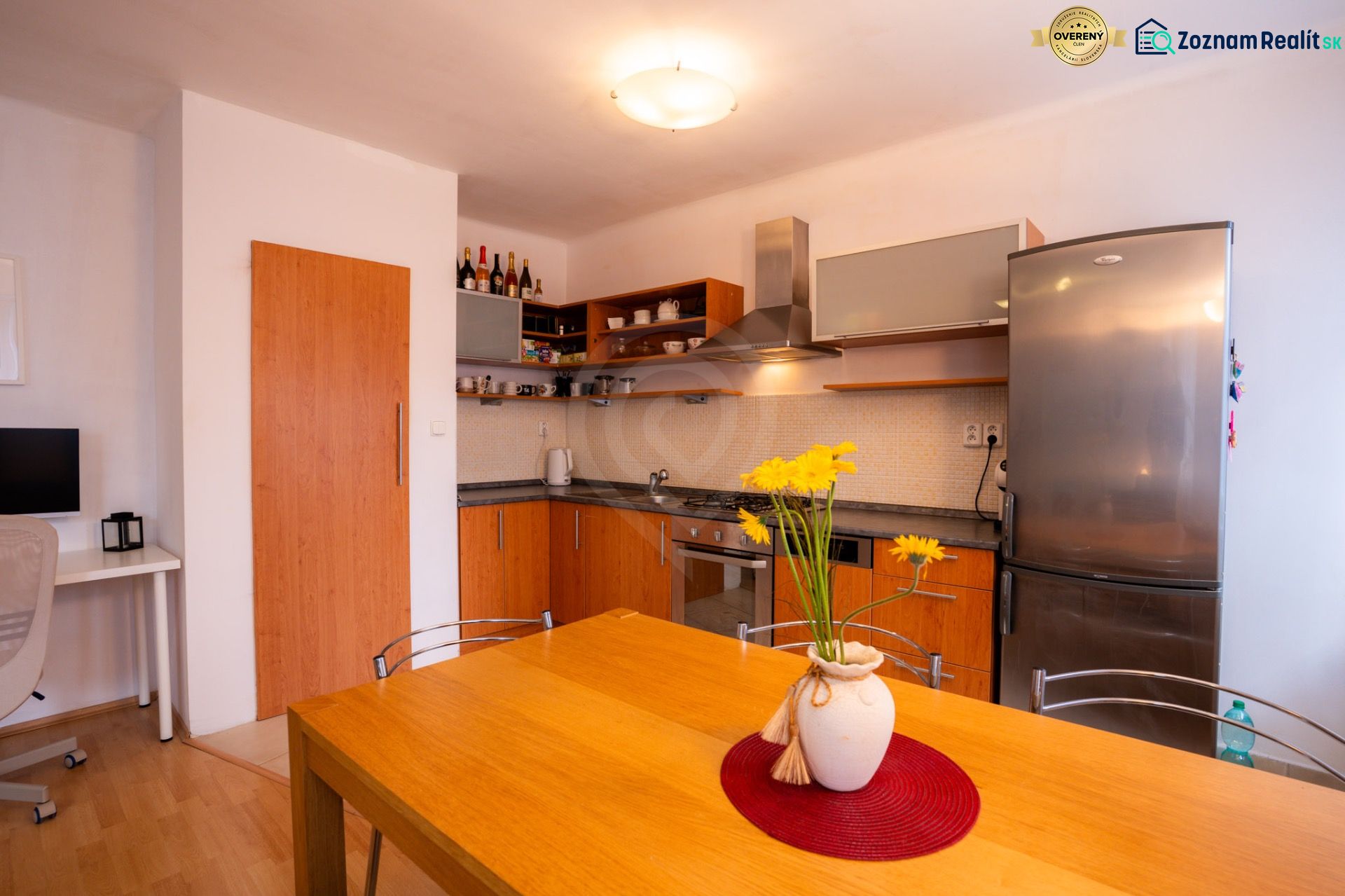 Küche in einer 4-Zimmer-Wohnung mit Holzdekor und gelbem Blumenzubehör.