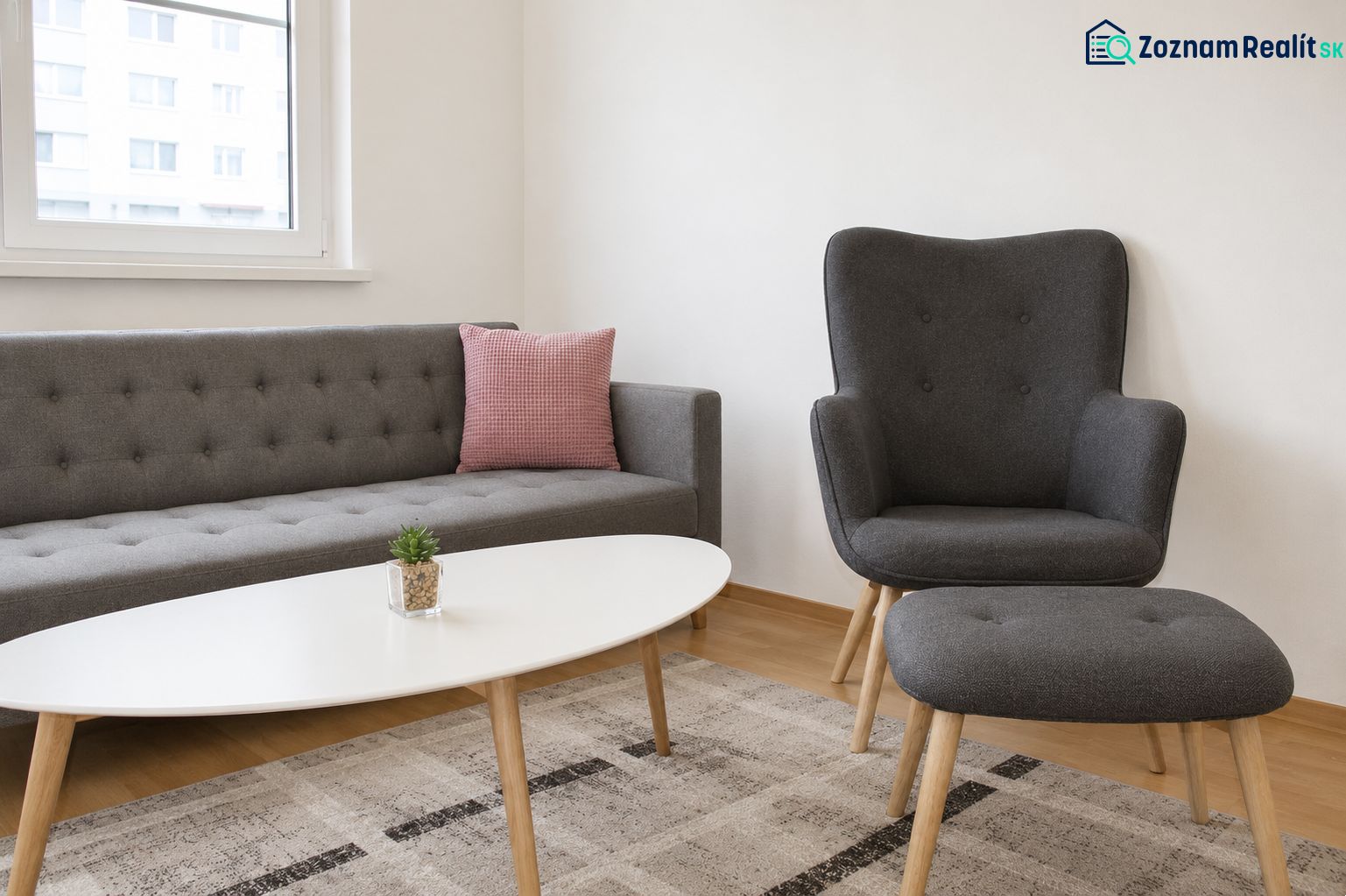 Wohnzimmer mit einem bequemen Sofa und einem Sessel in einer 2-Zimmer-Wohnung.