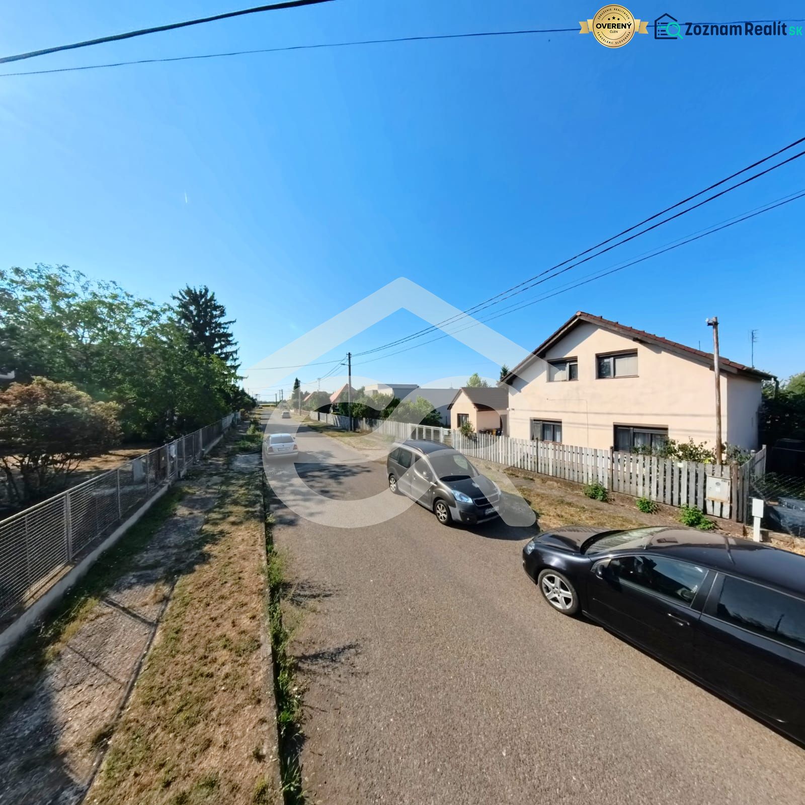 Ein Einfamilienhaus in der Prenosilova-Straße in Mojmírovce, neben der Straße mit Autos und Zäunen.