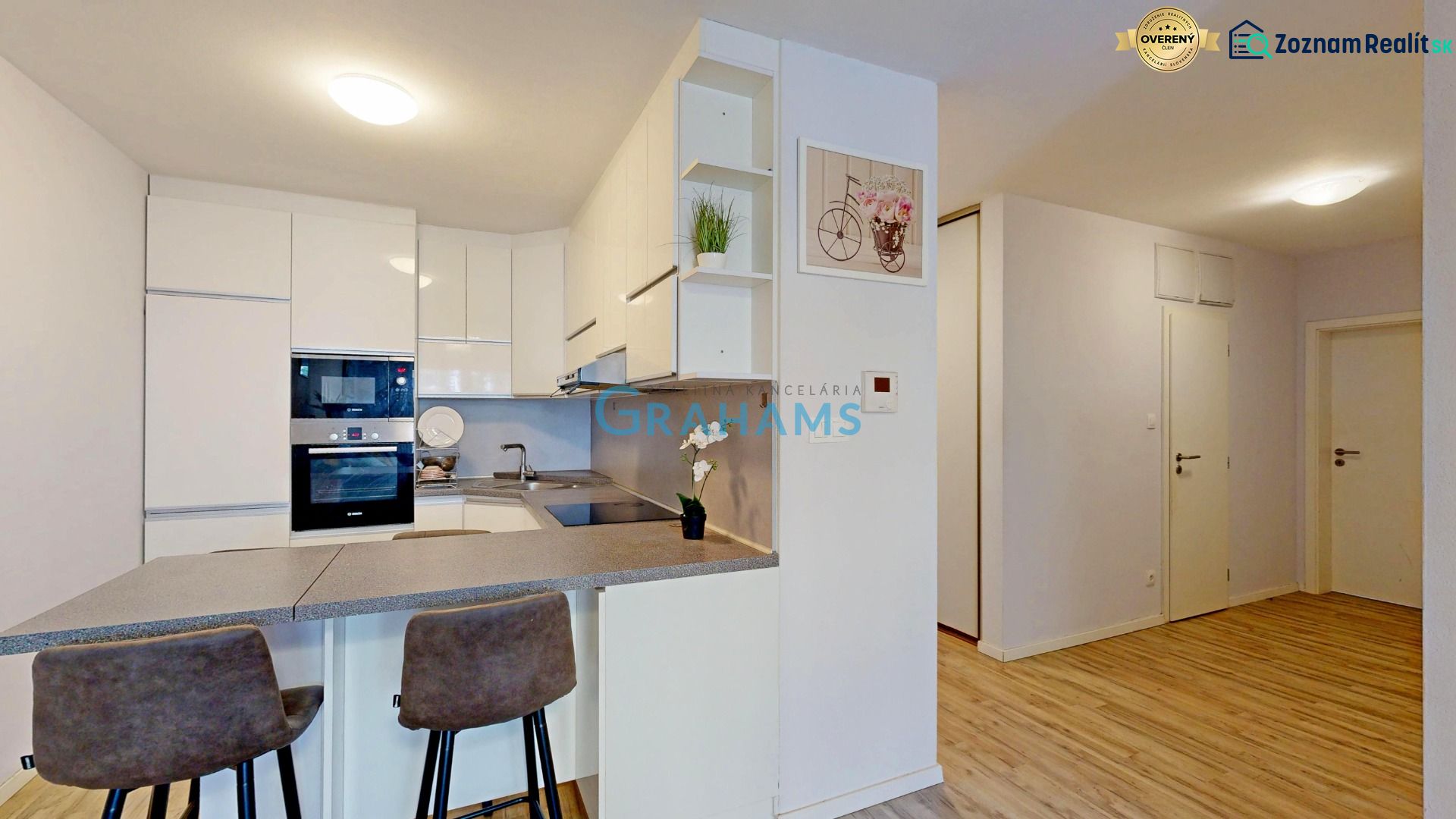 Küche mit Bartresen und Holzboden in einer 3-Zimmer-Wohnung.
