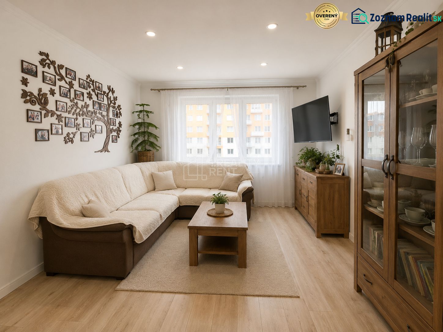 Wohnzimmer in einer 3-Zimmer-Wohnung mit einem bequemen Sofa und einem Boden in Holzoptik.