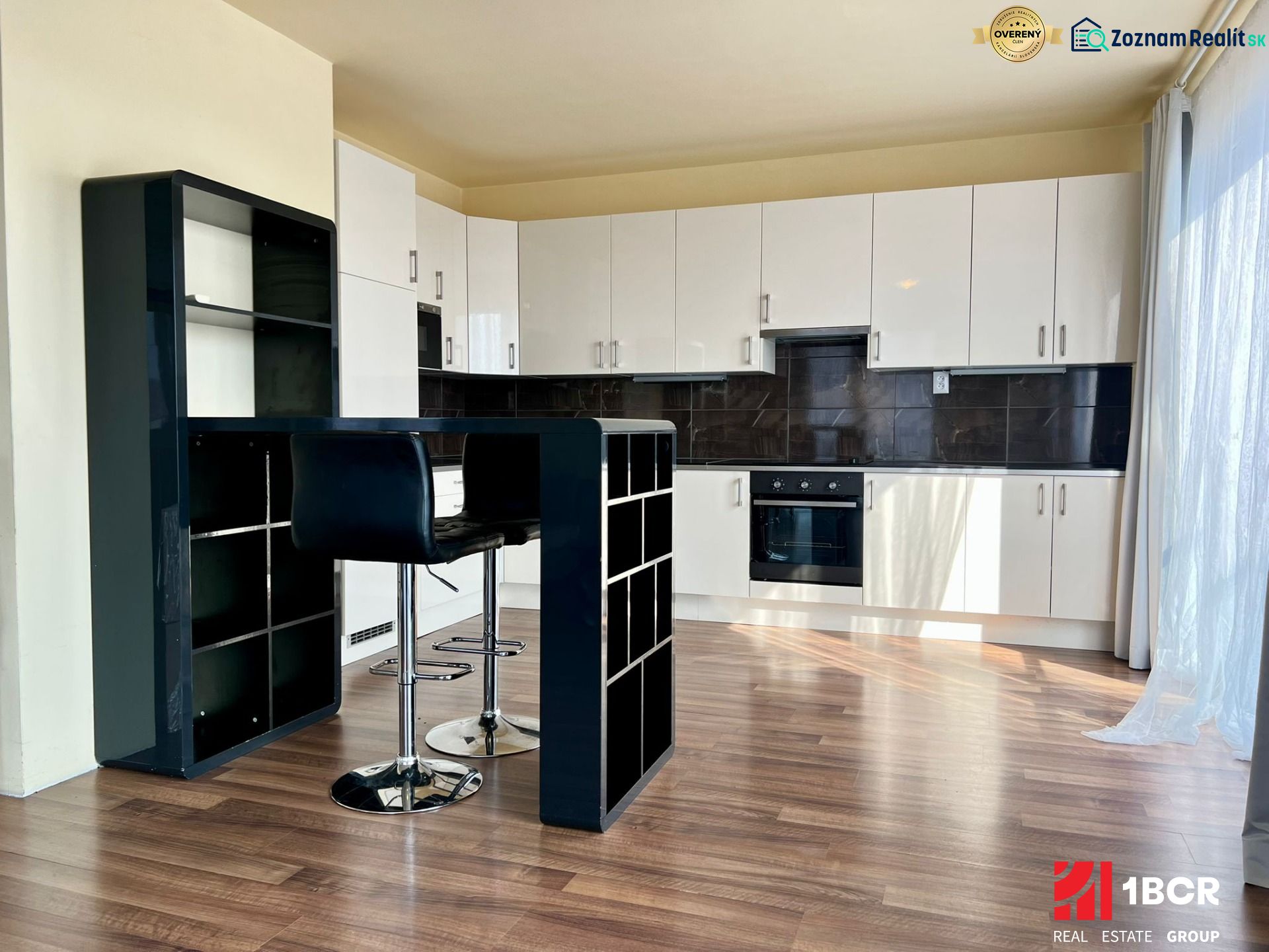 Küchenecke mit Bar und Holzboden in einer 2-Zimmer-Wohnung.