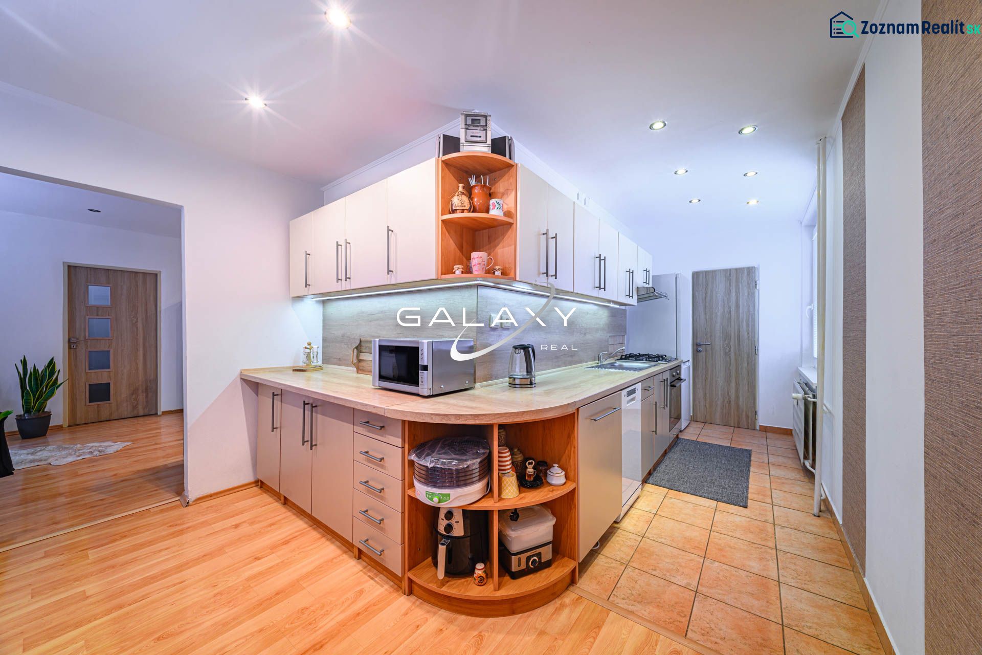 Küche in einer 2-Zimmer-Wohnung mit Holzboden und modernen Geräten.