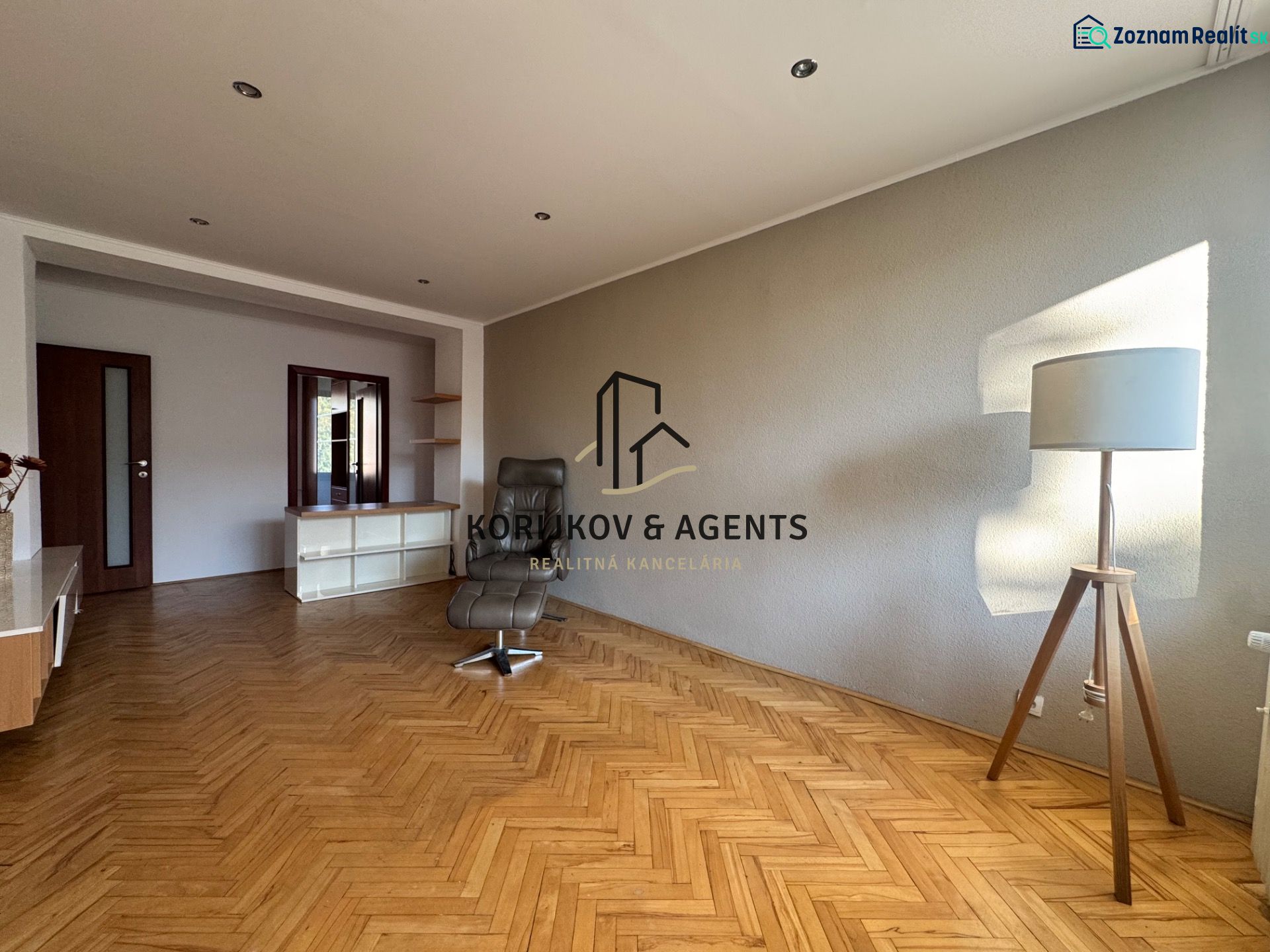 Wohnzimmer in einer 4-Zimmer-Wohnung mit Holzboden und einem bequemen Sessel.
