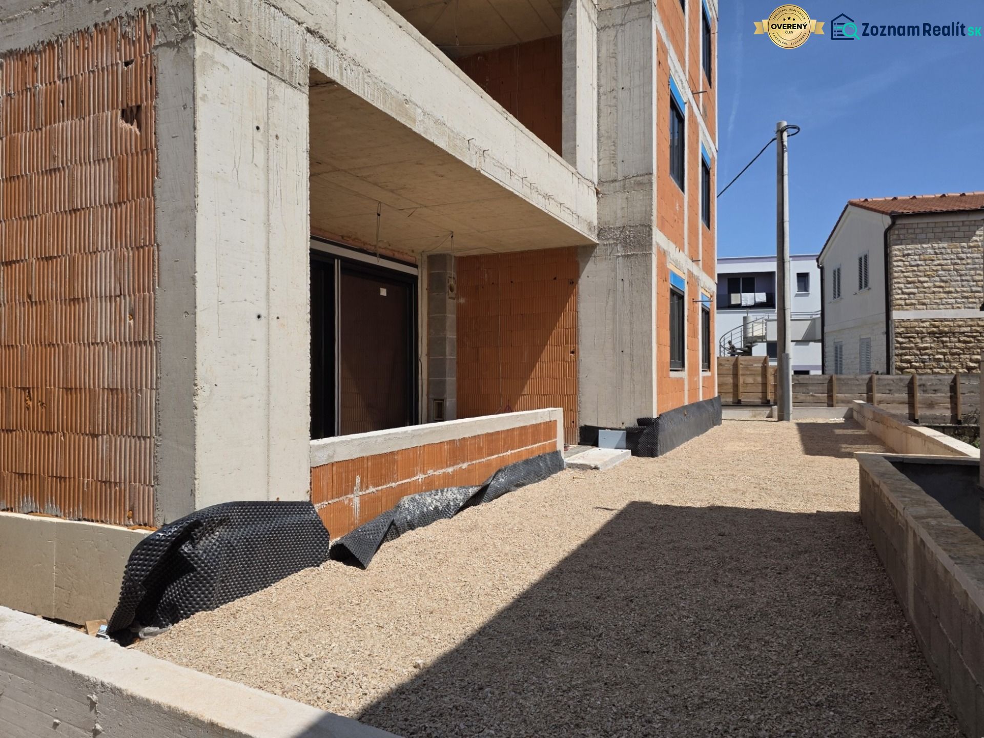 Bau einer 3-Zimmer-Wohnung in SRIMA, mit freiliegender Ziegelfassade und Kieshof.