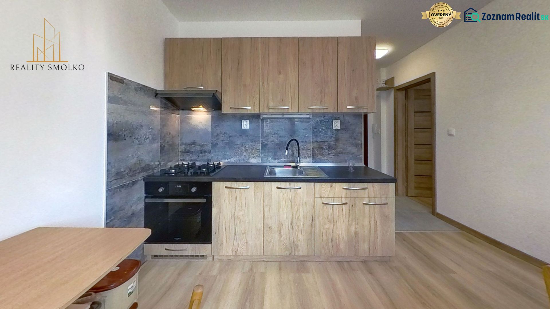 Küche mit Holzdekor und Arbeitsplatte in einer Einzimmerwohnung.