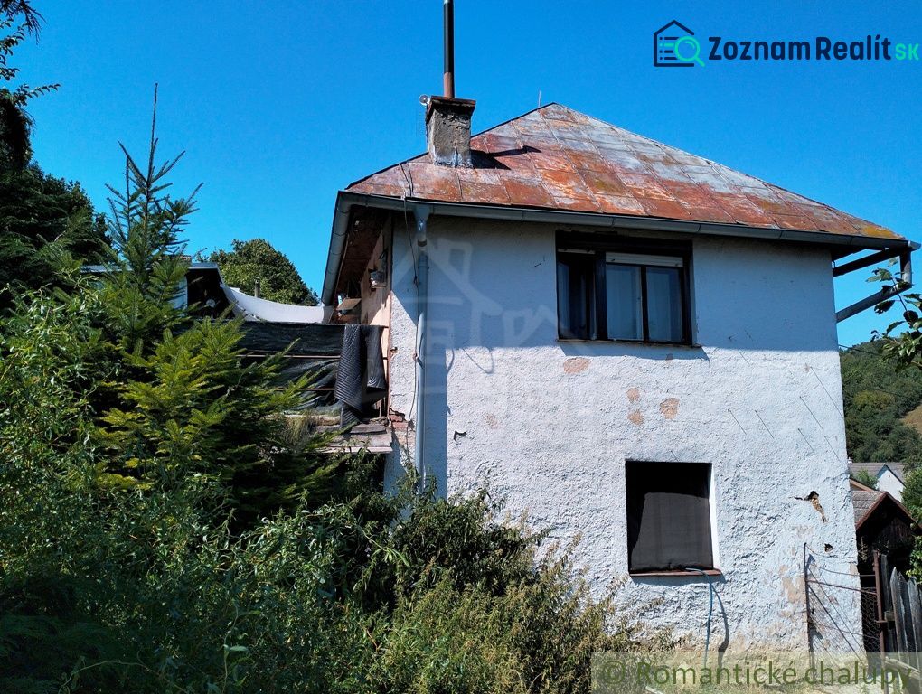 Ein Einfamilienhaus in Stará Turá mit einem abgenutzten Dach und überwucherter Umgebung.