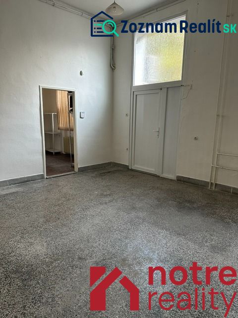 Innenraum eines Büros mit weißen Wänden und einem Boden in Betonoptik.