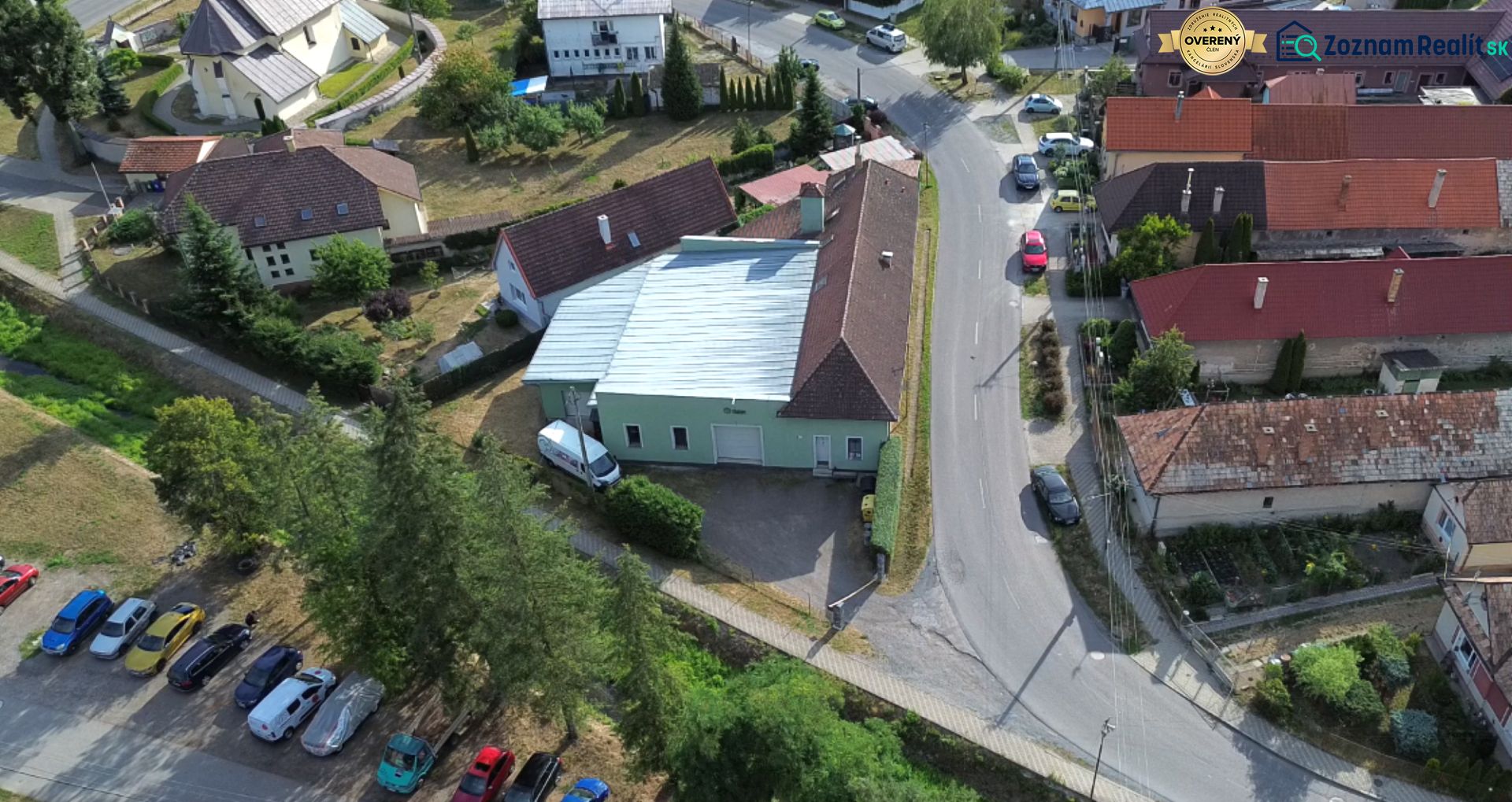 Eine Luftaufnahme der Produktionsräume in Budča, umgeben von Häusern und Grünflächen.