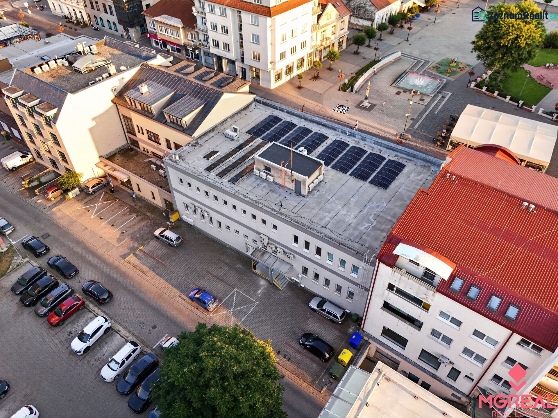 Luftaufnahme von Geschäftsräumen in der M.R. Štefánika-Straße in Topoľčany mit Parkplatz.