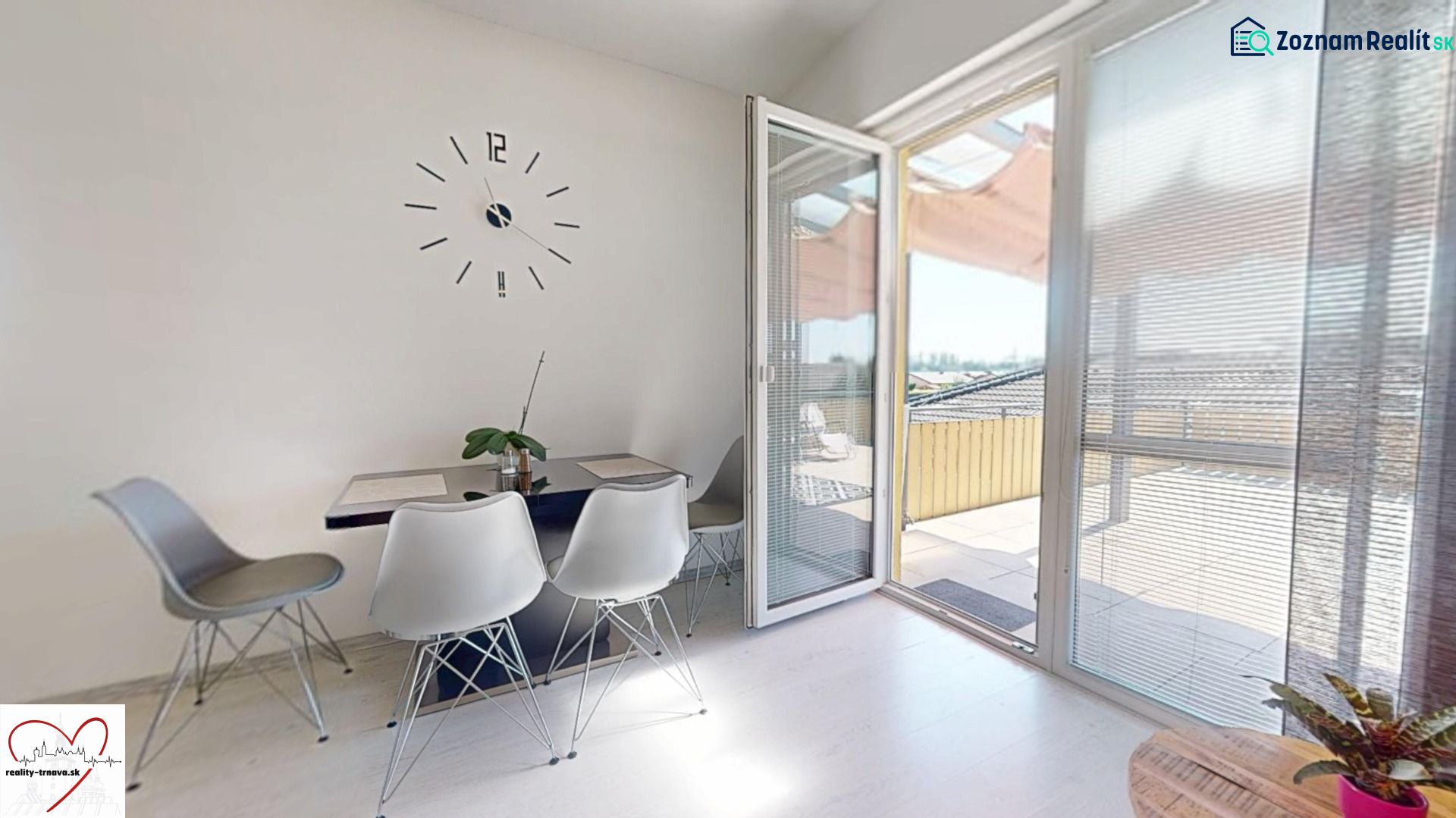Essbereich mit Uhr und offenem Balkon in einer 3-Zimmer-Wohnung.