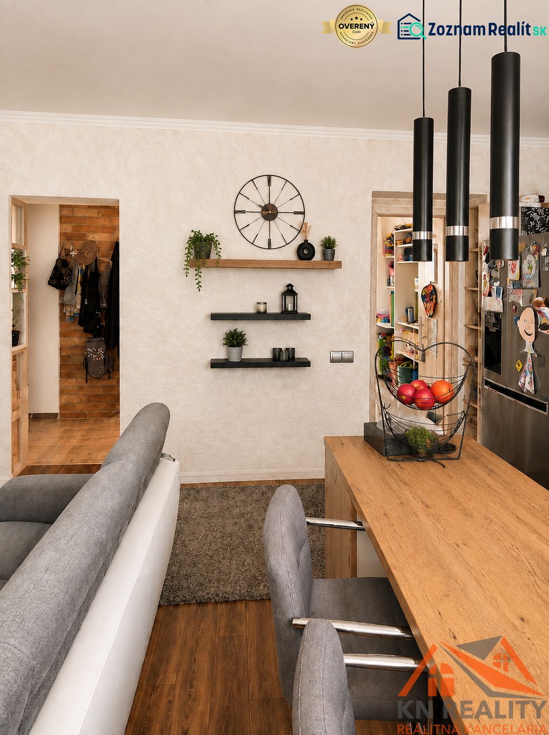 Innenraum einer 3-Zimmer-Wohnung mit Holzboden, bequemen Sitzgelegenheiten und Regalen.