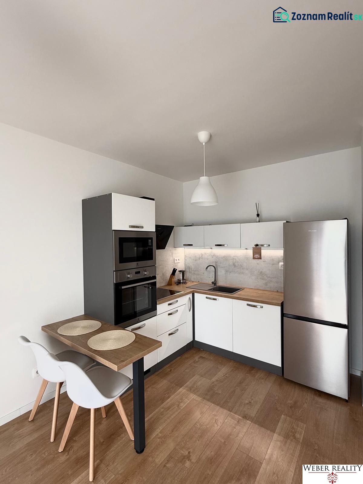 Küche in einer 2-Zimmer-Wohnung mit Eckküche und Boden in Holzoptik.