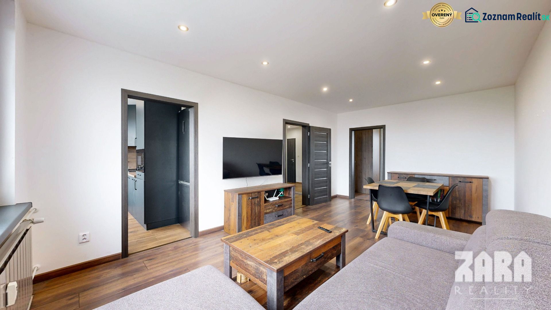 Wohnzimmer mit Holzboden und Möbeln in einer Vierzimmerwohnung.