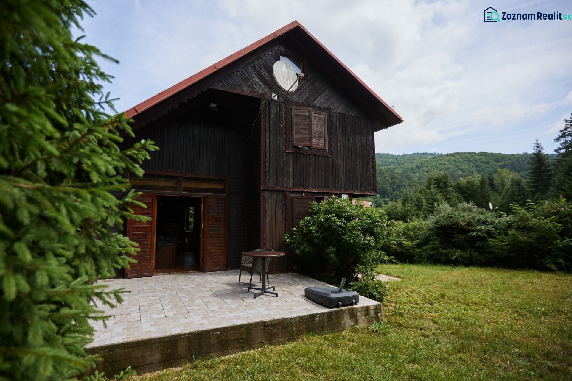 Das Haus auf Rovnom 61 in Jaklovce mit einer Holzfassade und einer Terrasse, umgeben von Grün.