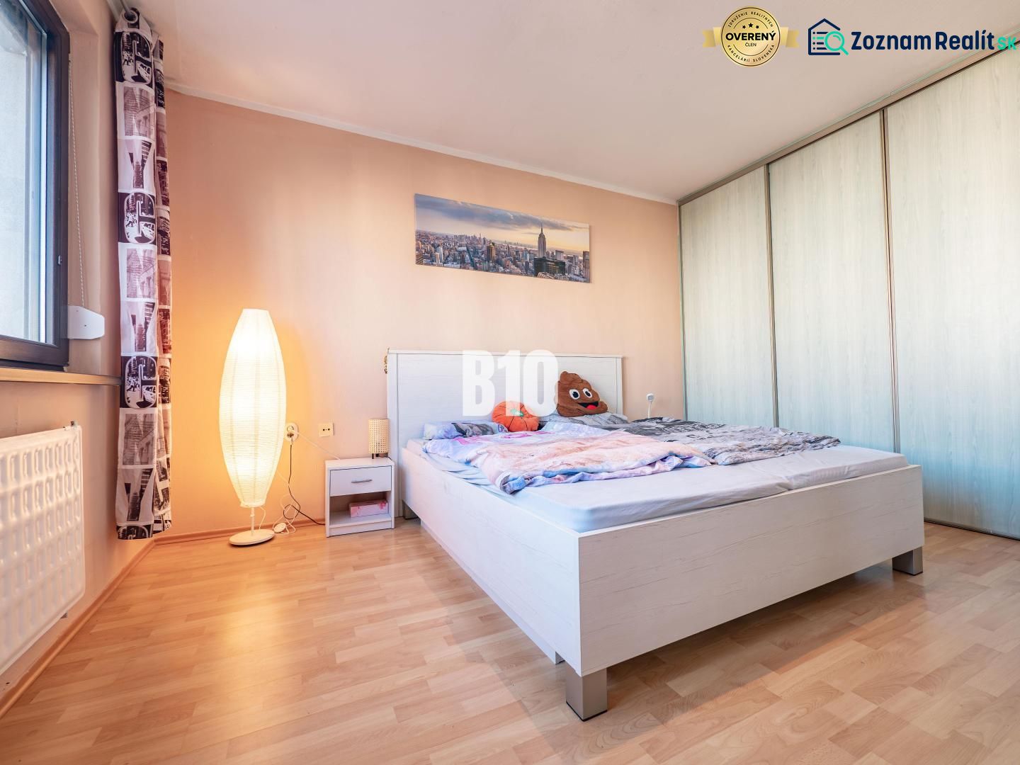 Schlafzimmer mit Holzboden, Bett und Schrank in einer Einzimmerwohnung.