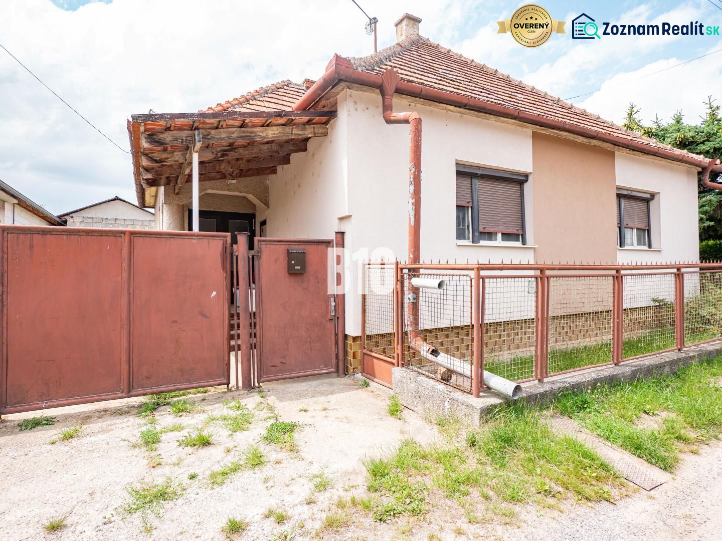 Ein Einfamilienhaus in Nitra mit einem Blechzaun und einem Schrägdach.