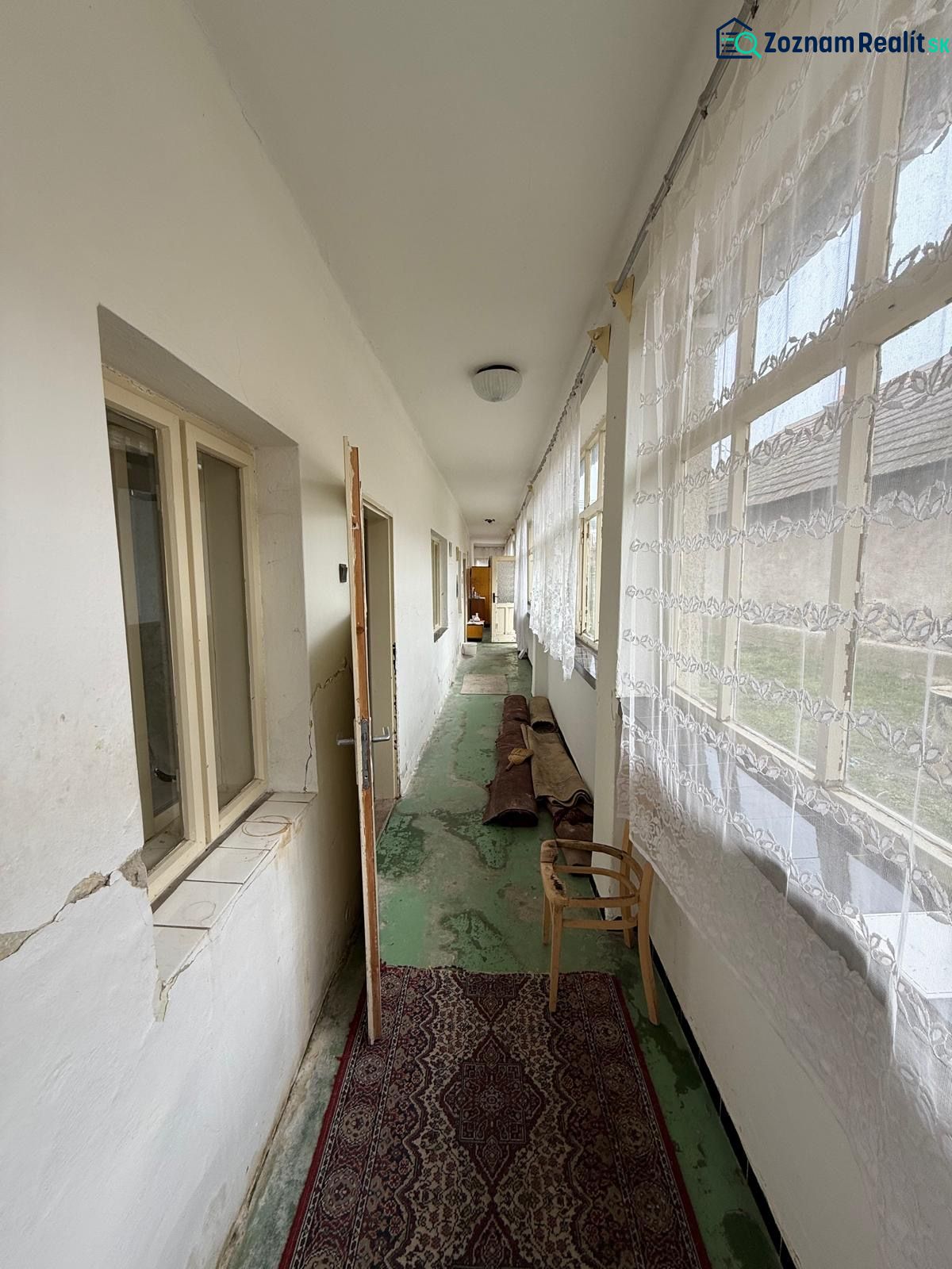 Ein heller Flur in einem Einfamilienhaus mit Teppich und Vorhängen.