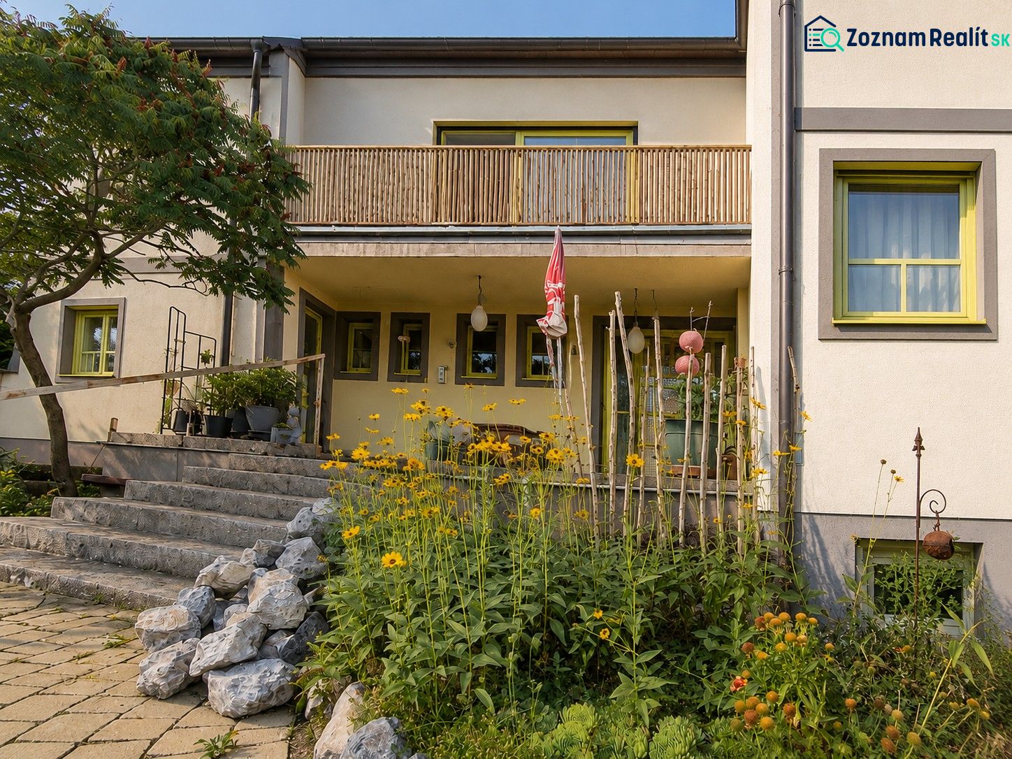 Ein Einfamilienhaus in Podersdorf am See mit Steintreppen und einem Garten voller Blumen.