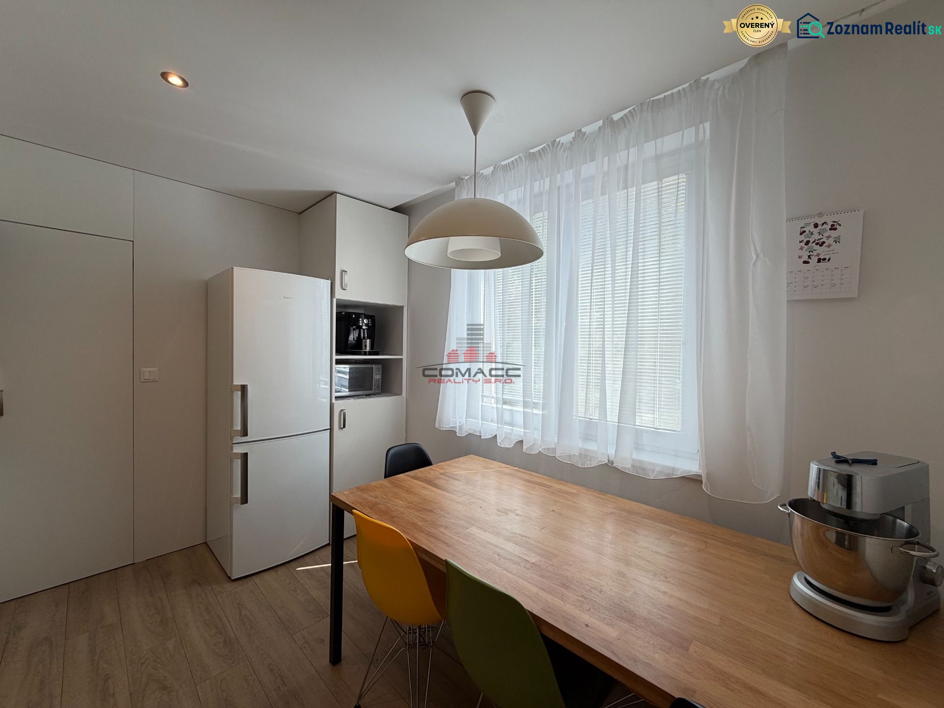Eine Küche in hellen Farben mit einem Holzboden in einer 3-Zimmer-Wohnung.