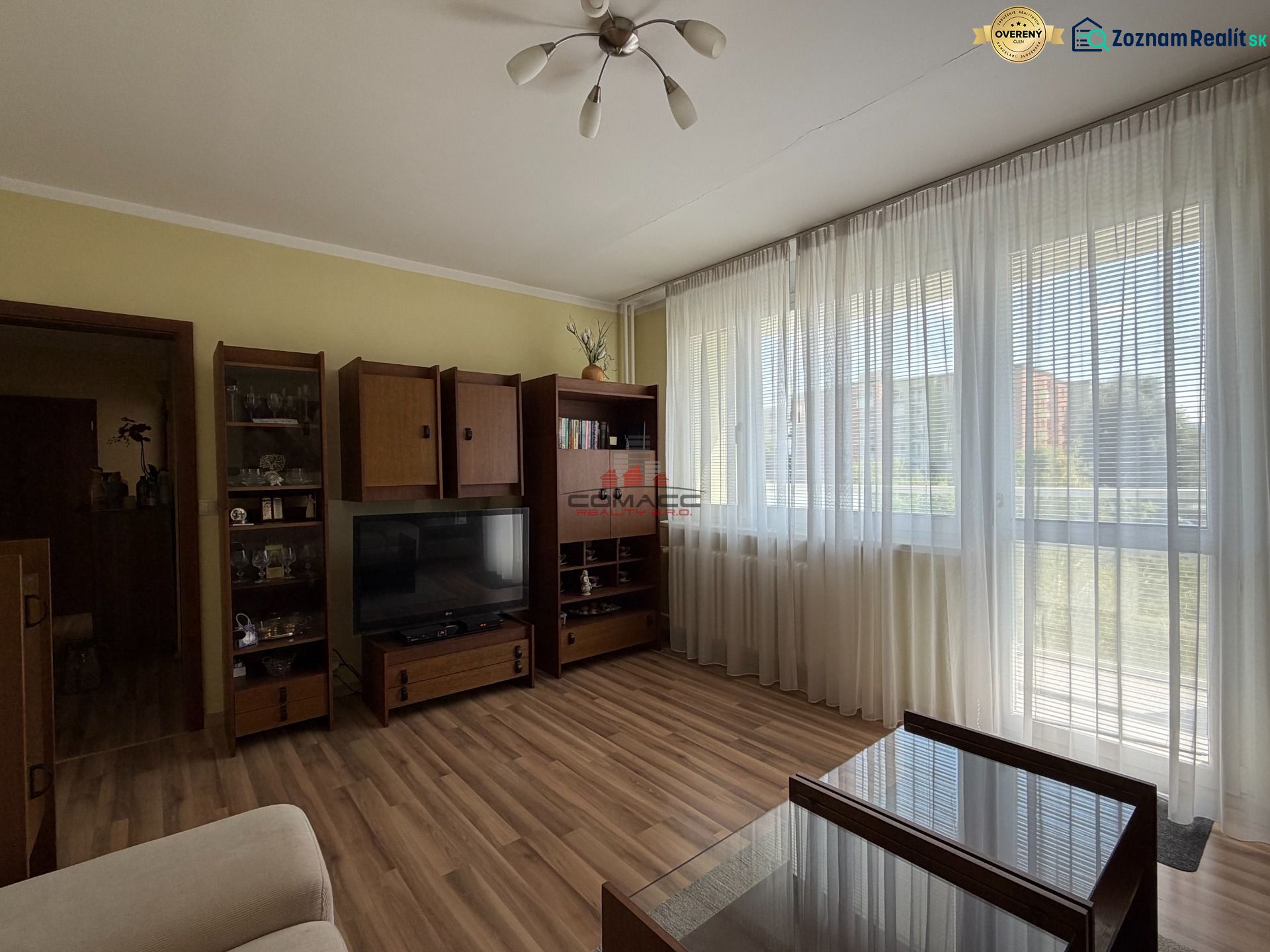 Wohnzimmer in einer 3-Zimmer-Wohnung mit Holzboden und großen Fenstern.