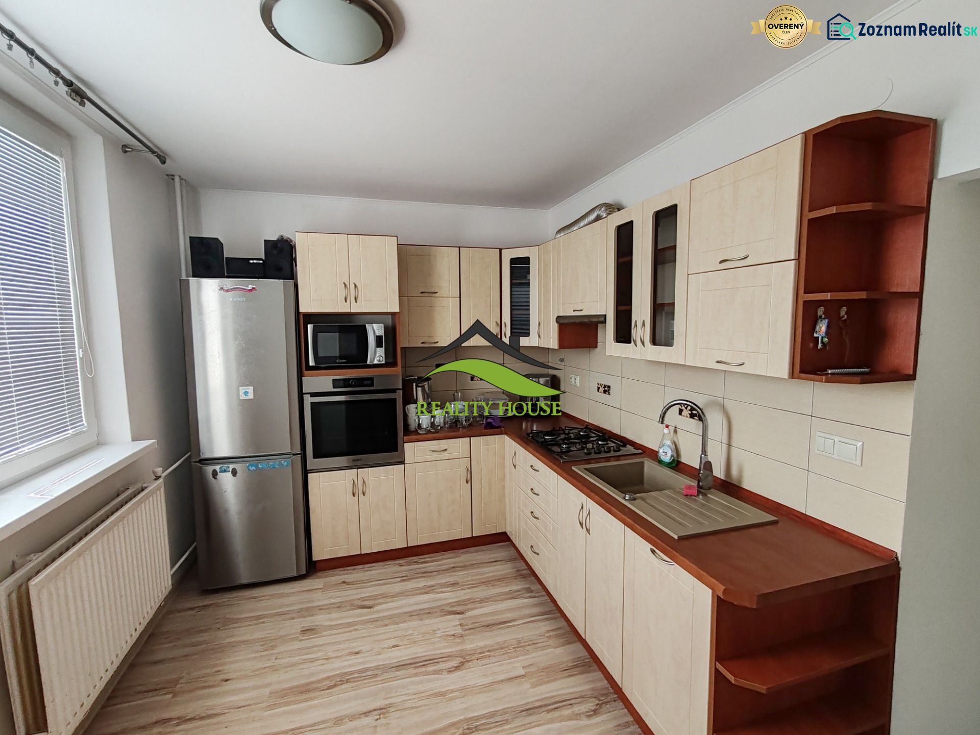 Küche in einer 3-Zimmer-Wohnung mit Holzboden und Geräten.