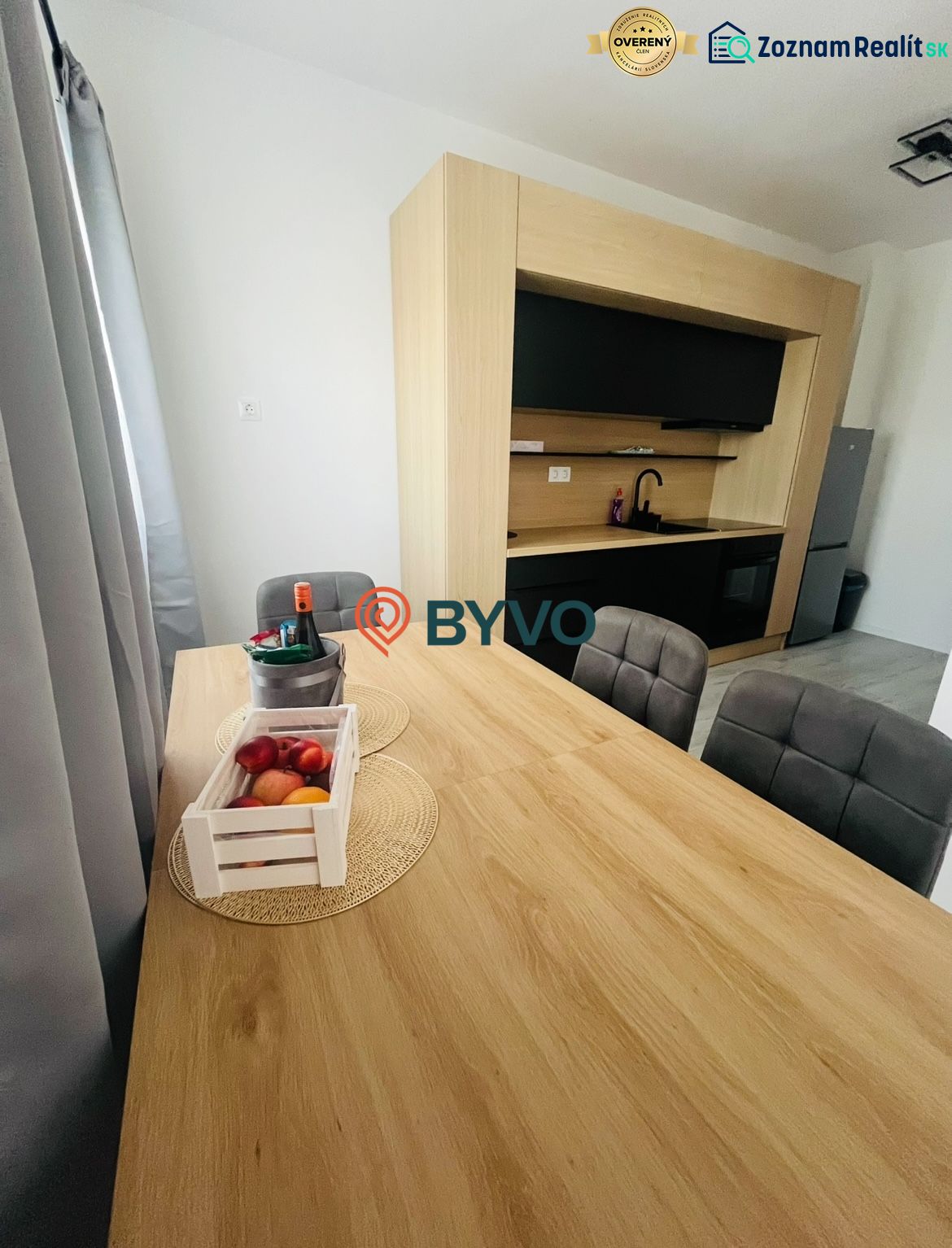 Küche in einer 2-Zimmer-Wohnung mit Esstisch und Boden in Holzoptik.