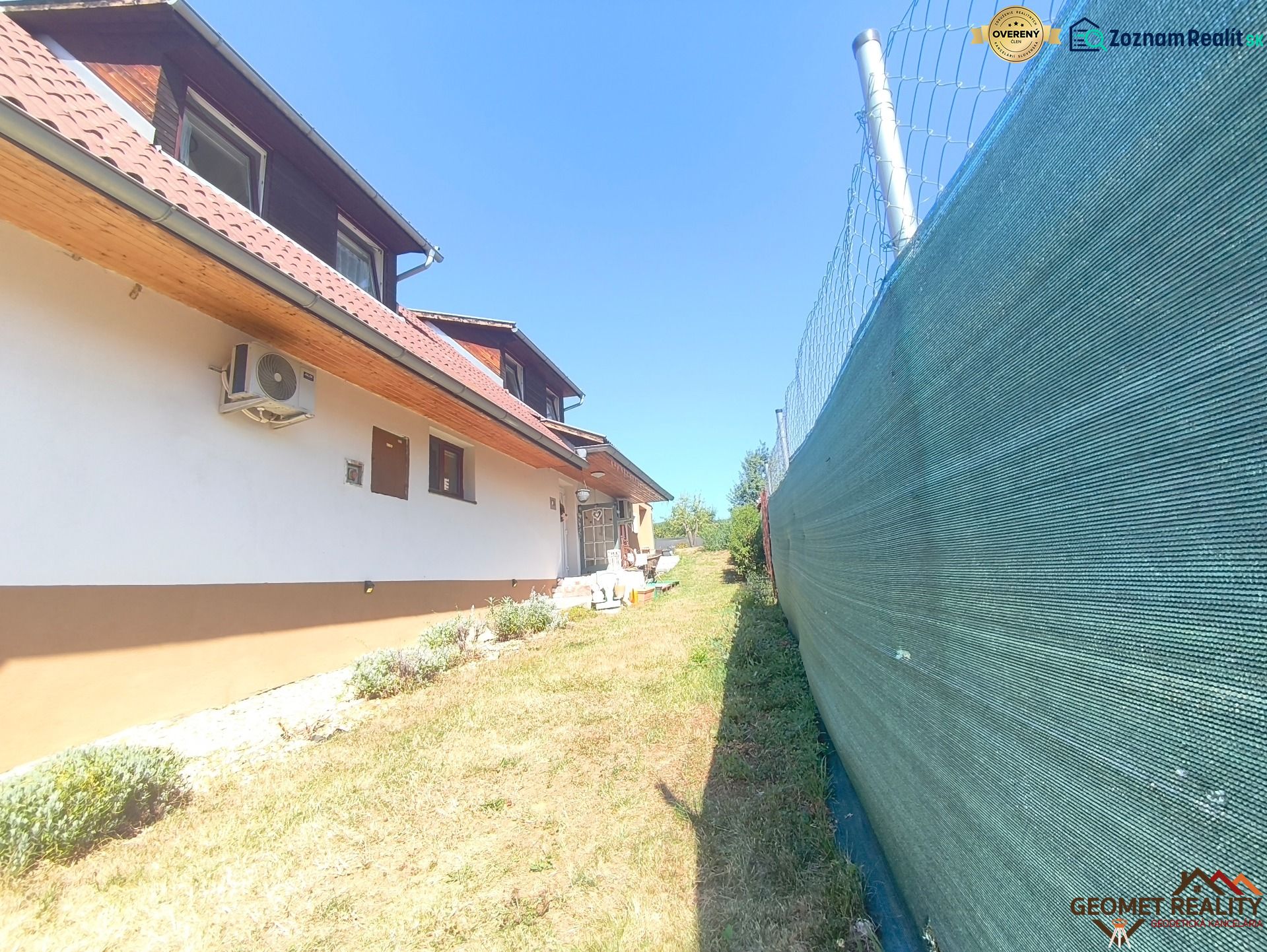 Ein Einfamilienhaus in Divín mit Klimaanlage, Umzäunung und Garten mit Rasen.