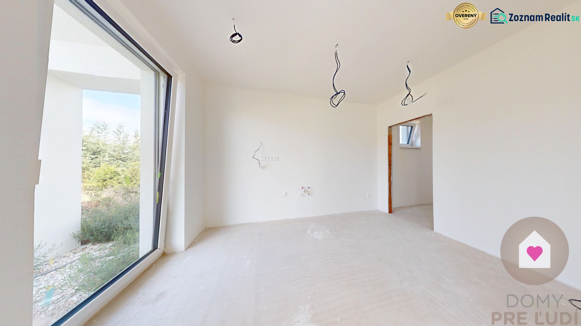 Helles Zimmer mit großem Fenster und Betonboden in einem Einfamilienhaus.
