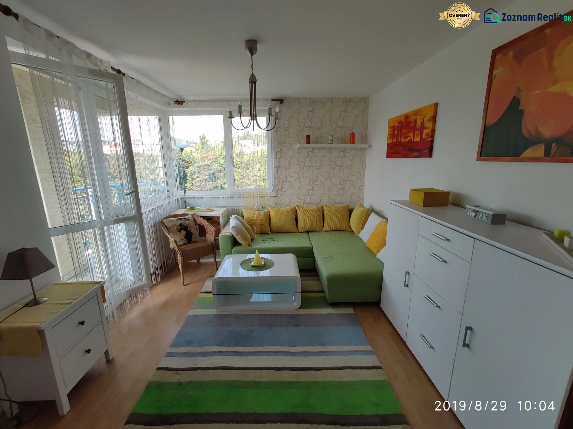 Wohnzimmer in einer 2-Zimmer-Wohnung mit Ecksofa und Holzboden.