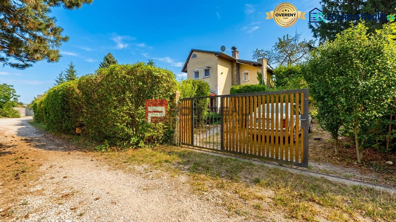 Das Haus bei Alžbeta Hof in Miloslavov, umgeben von Grün und einem Holzzaun.