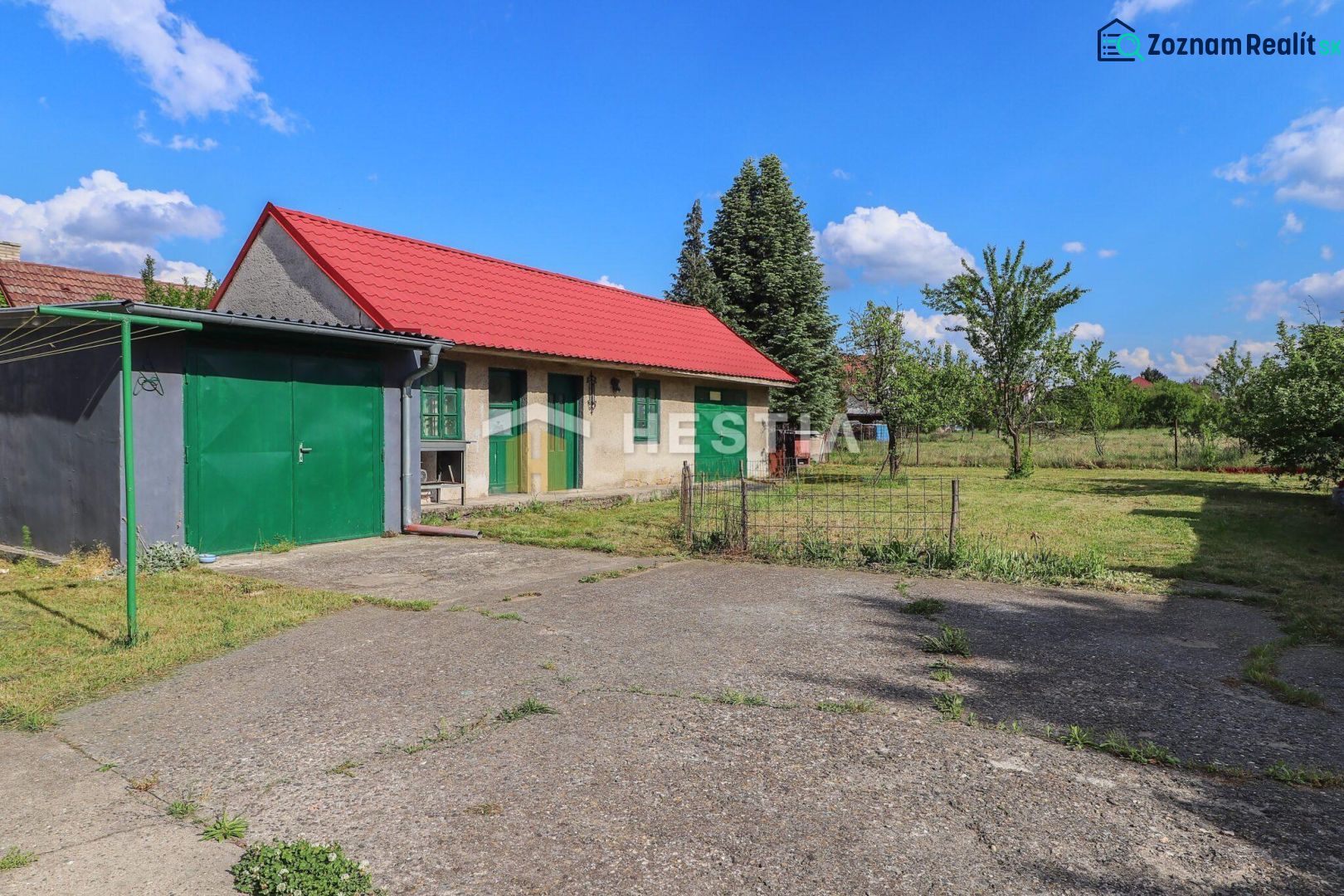 Ein Einfamilienhaus in Borský Mikuláš mit einem Rasen im Garten und einem roten Dach.