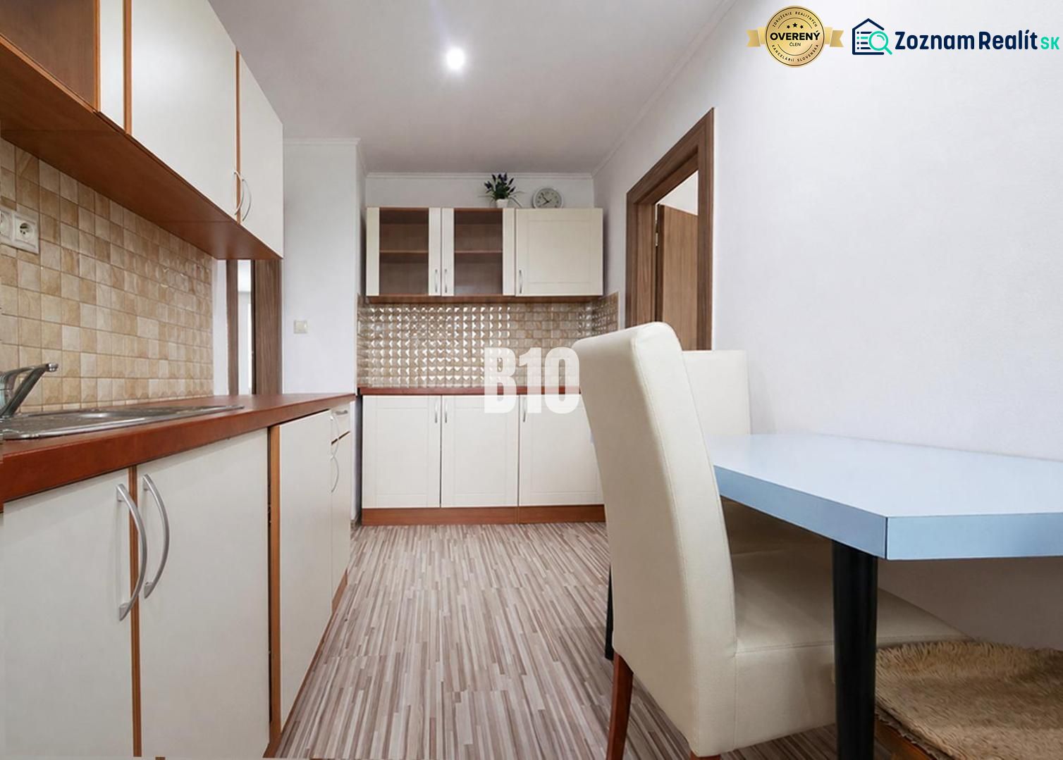 Küche in einer 3-Zimmer-Wohnung mit Holzboden und hellen Möbeln.
