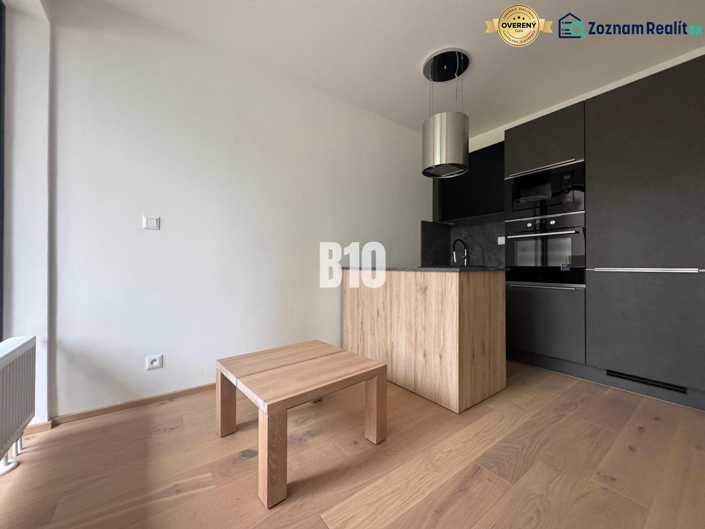 Küchenecke mit dunklen Schränken und Holzboden in einer 2-Zimmer-Wohnung.
