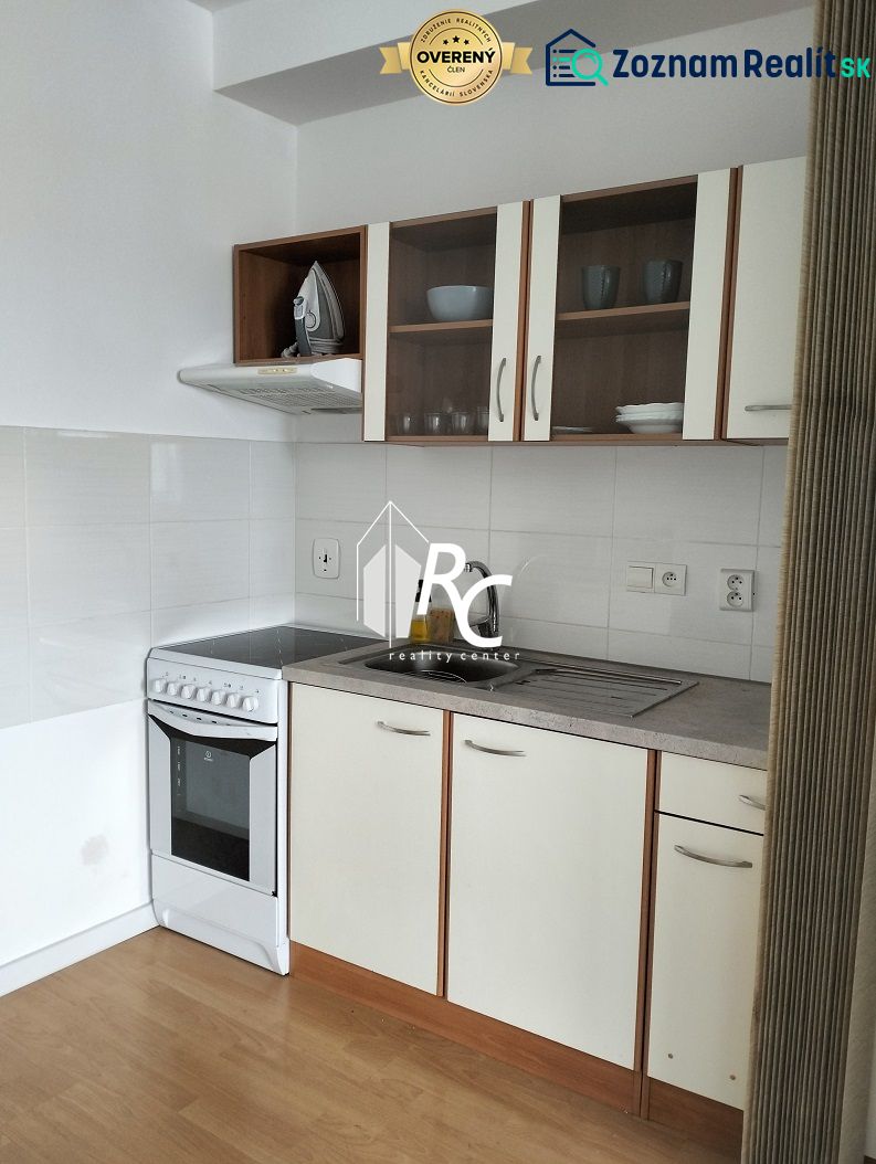 Küche mit weißen Schränken in einer 2-Zimmer-Wohnung, Boden mit Holzdekor.