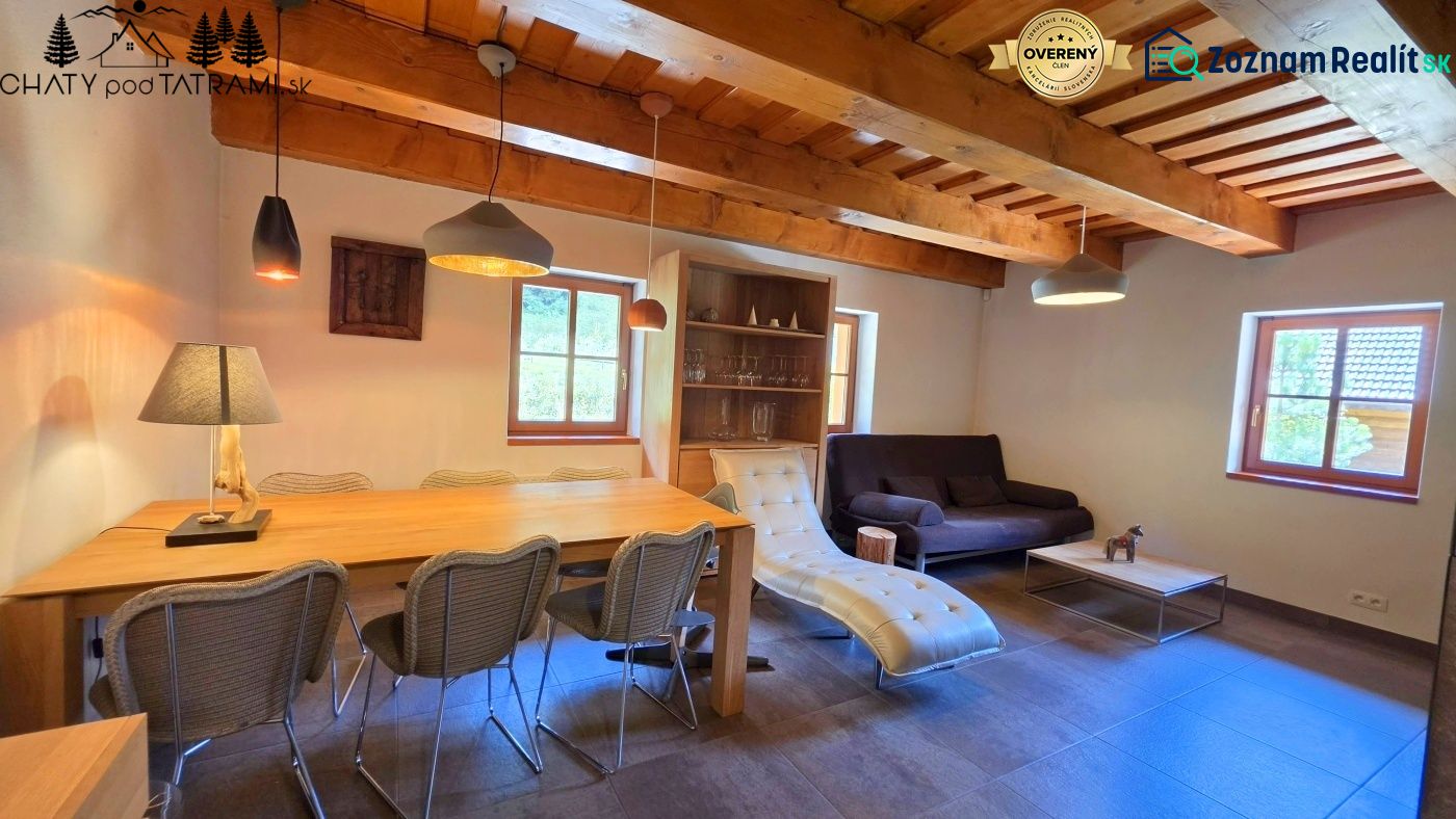 Das Innere der Hütte mit einer mit Holz verzierten Decke, bequemen Möbeln und dekorativer Beleuchtung.